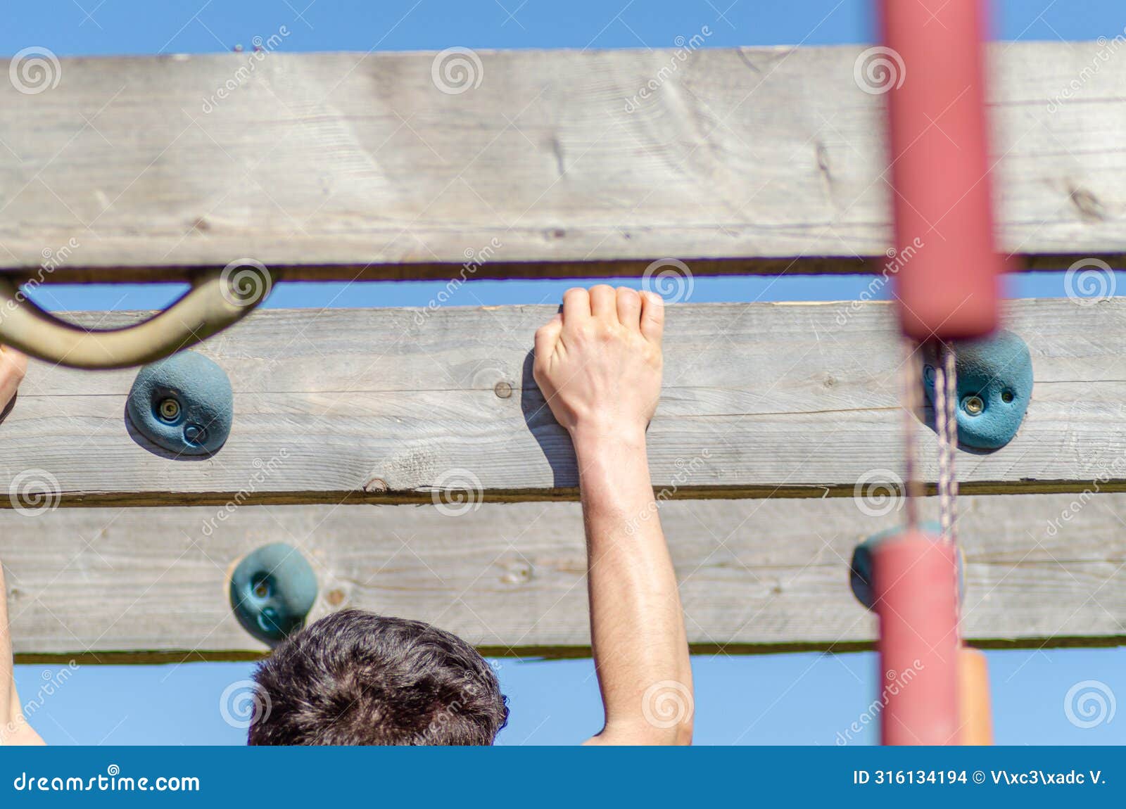 detail of an athlete hanging from an obstacle at an obstacle course race, ocr