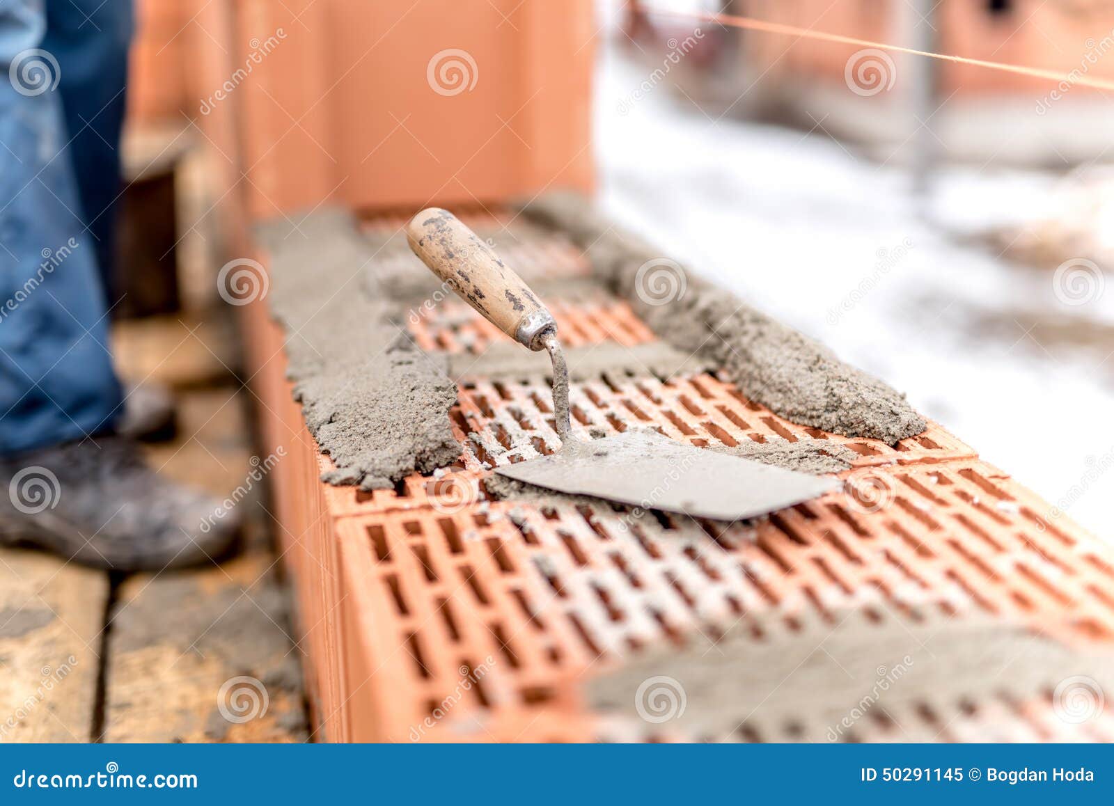 detail of construction site, trowel or putty knife on top of brick layer
