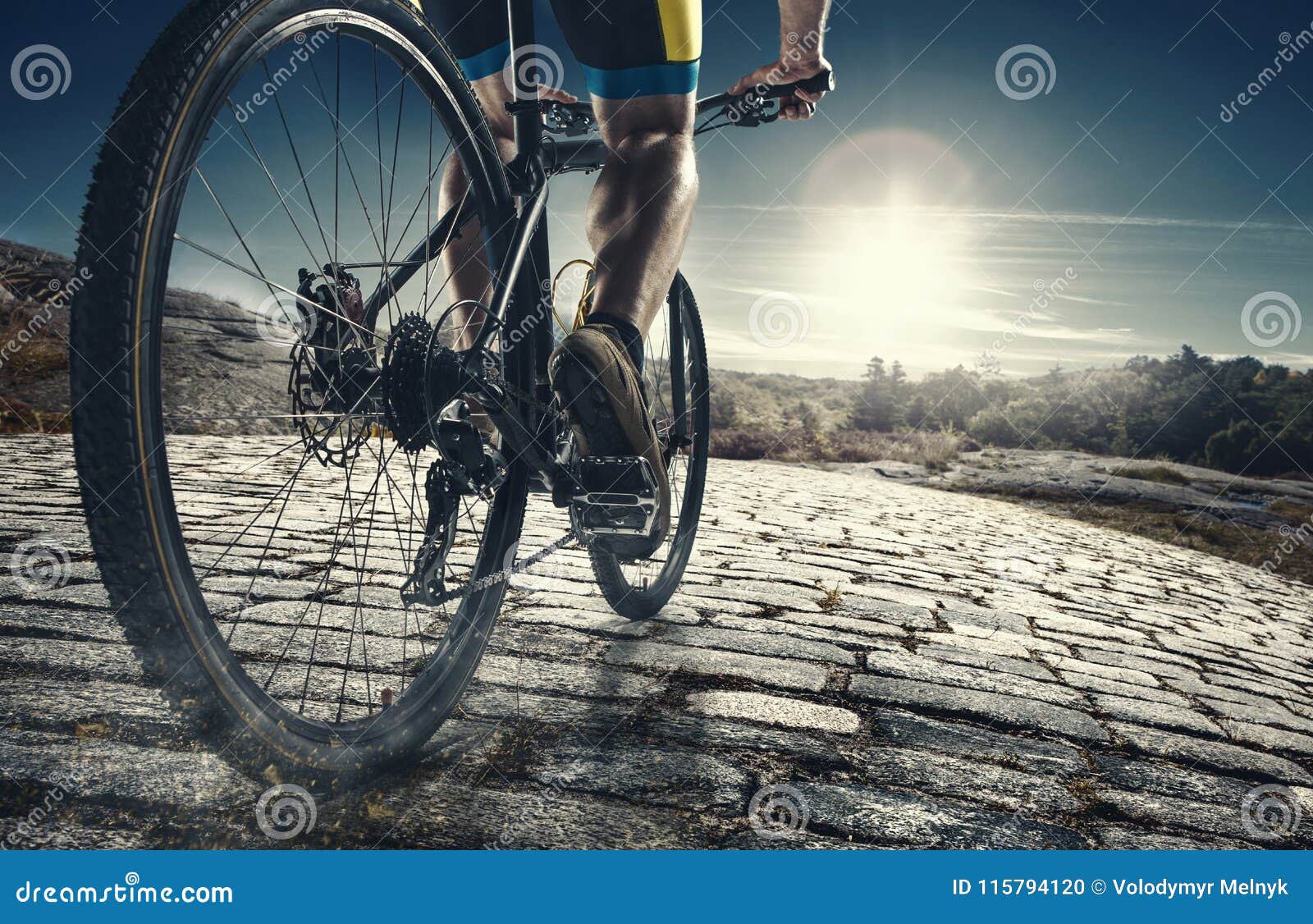 detail of cyclist man feet riding mountain bike on outdoor trail on country road