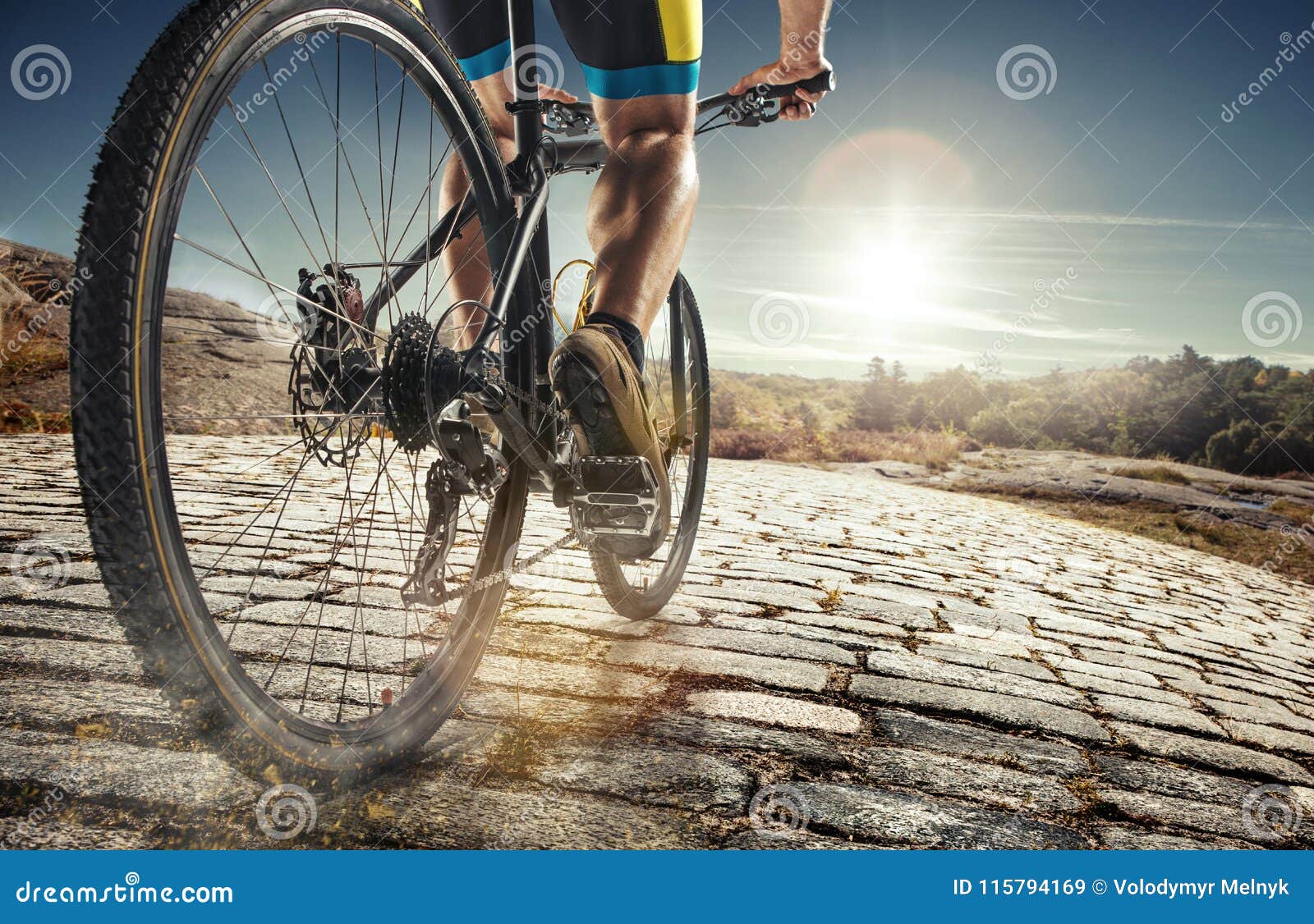 detail of cyclist man feet riding mountain bike on outdoor trail on country road