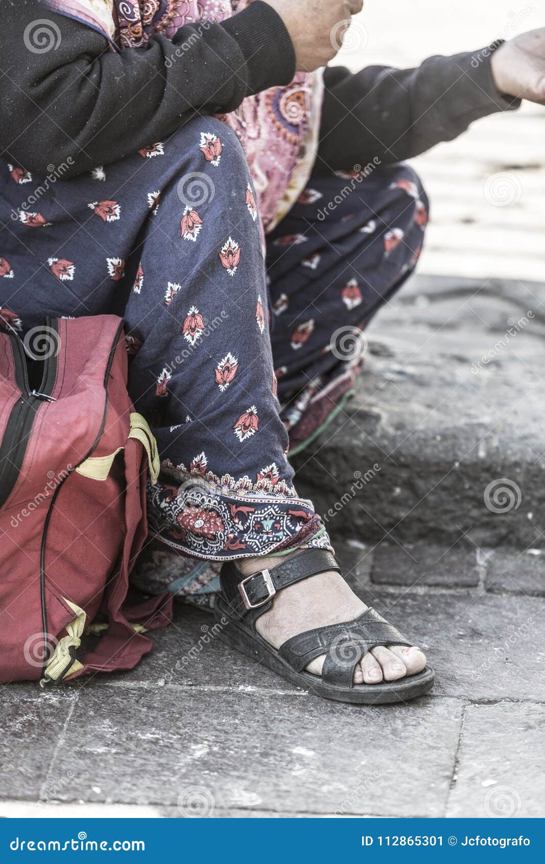 detail of the feet of the homeless woman
