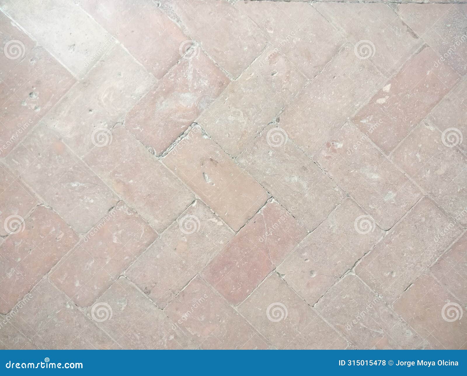detail of a floor with reddish and beige mix bricks.