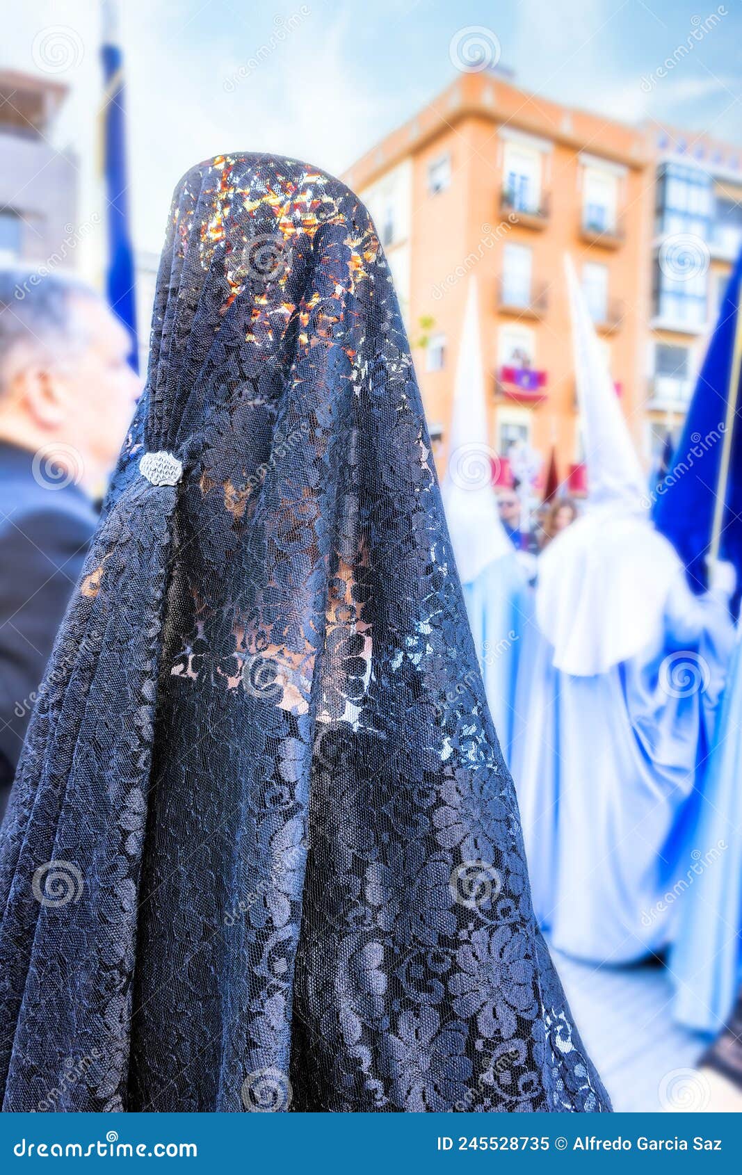 detail of the head of a woman with a black spanish mantilla and peineta ornamental comb, seen from behind, in a holy week