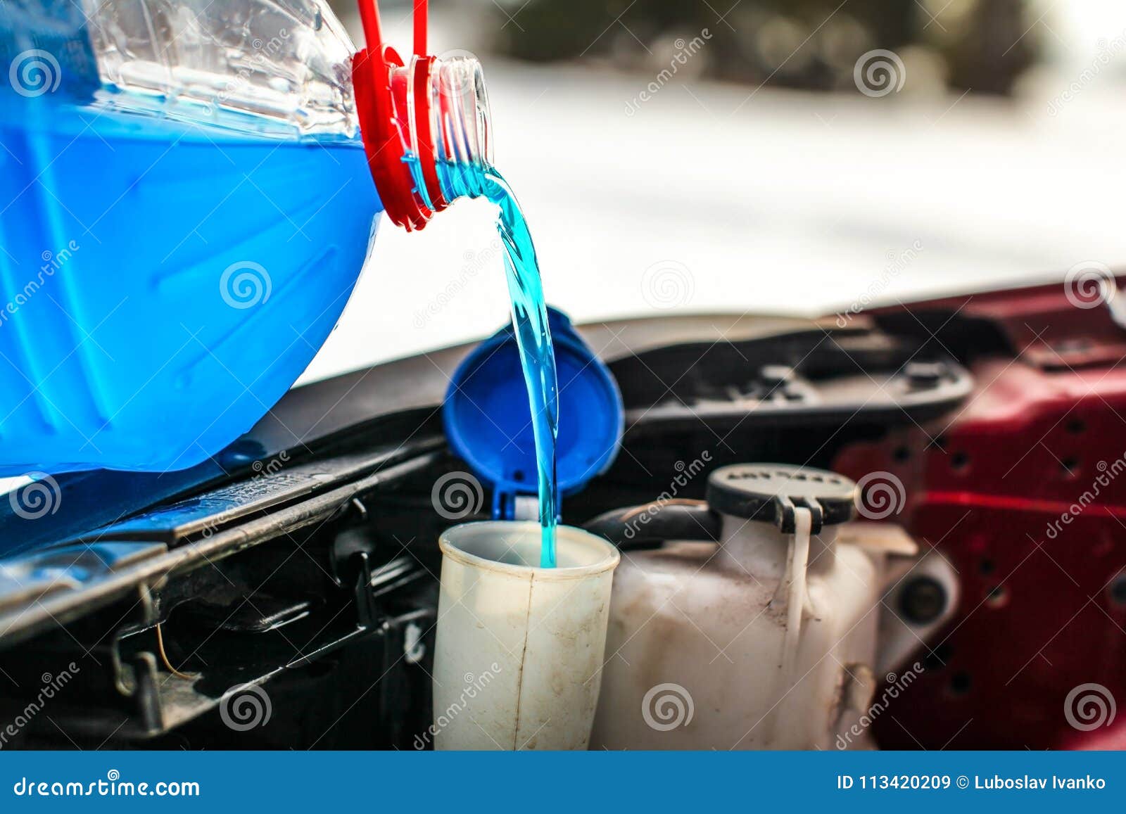 detail on pouring antifreeze liquid screen wash into dirty car