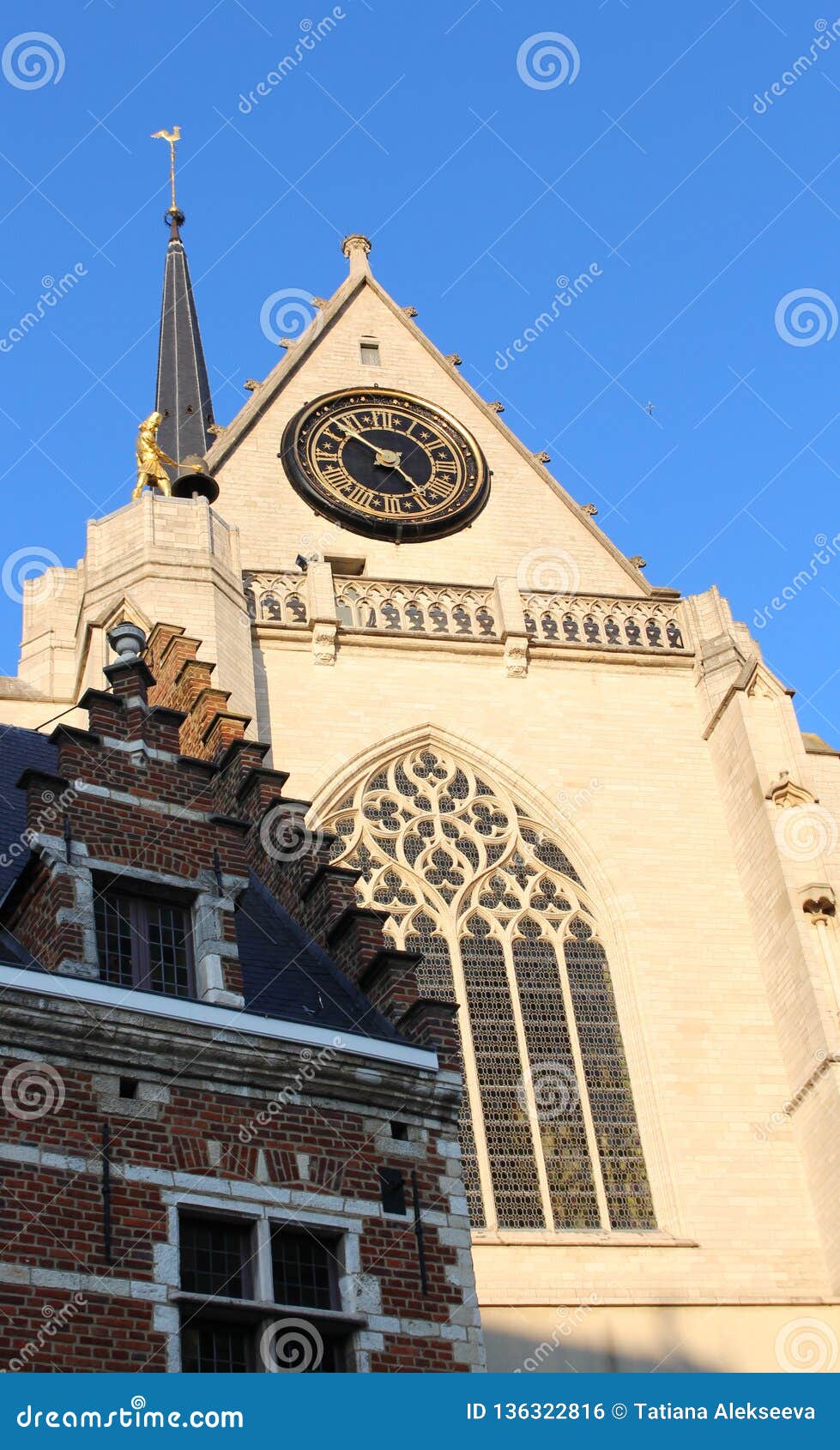 detail of saint peter`s church and a brick ancien house on a sunny day, leuven, belgium