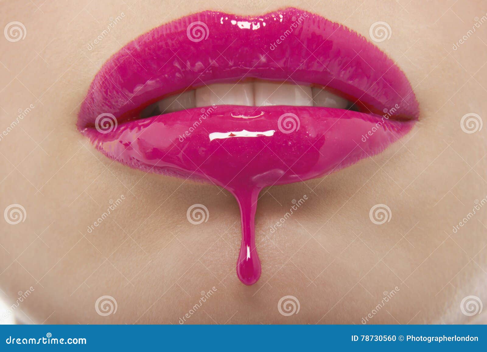 detail shot of pink lipgloss dripping from woman's lips