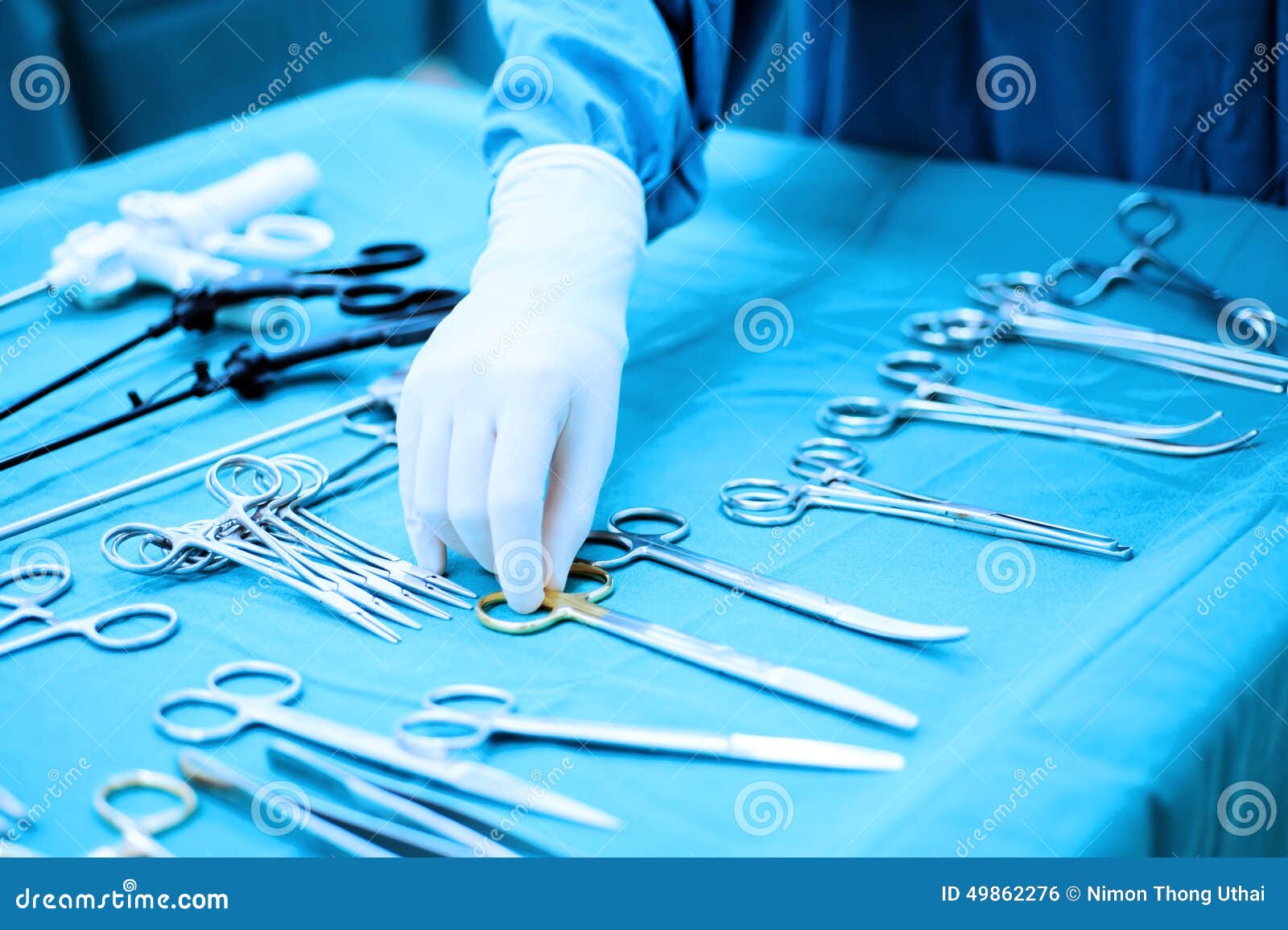 detail shot of steralized surgery instruments with a hand grabbing a tool