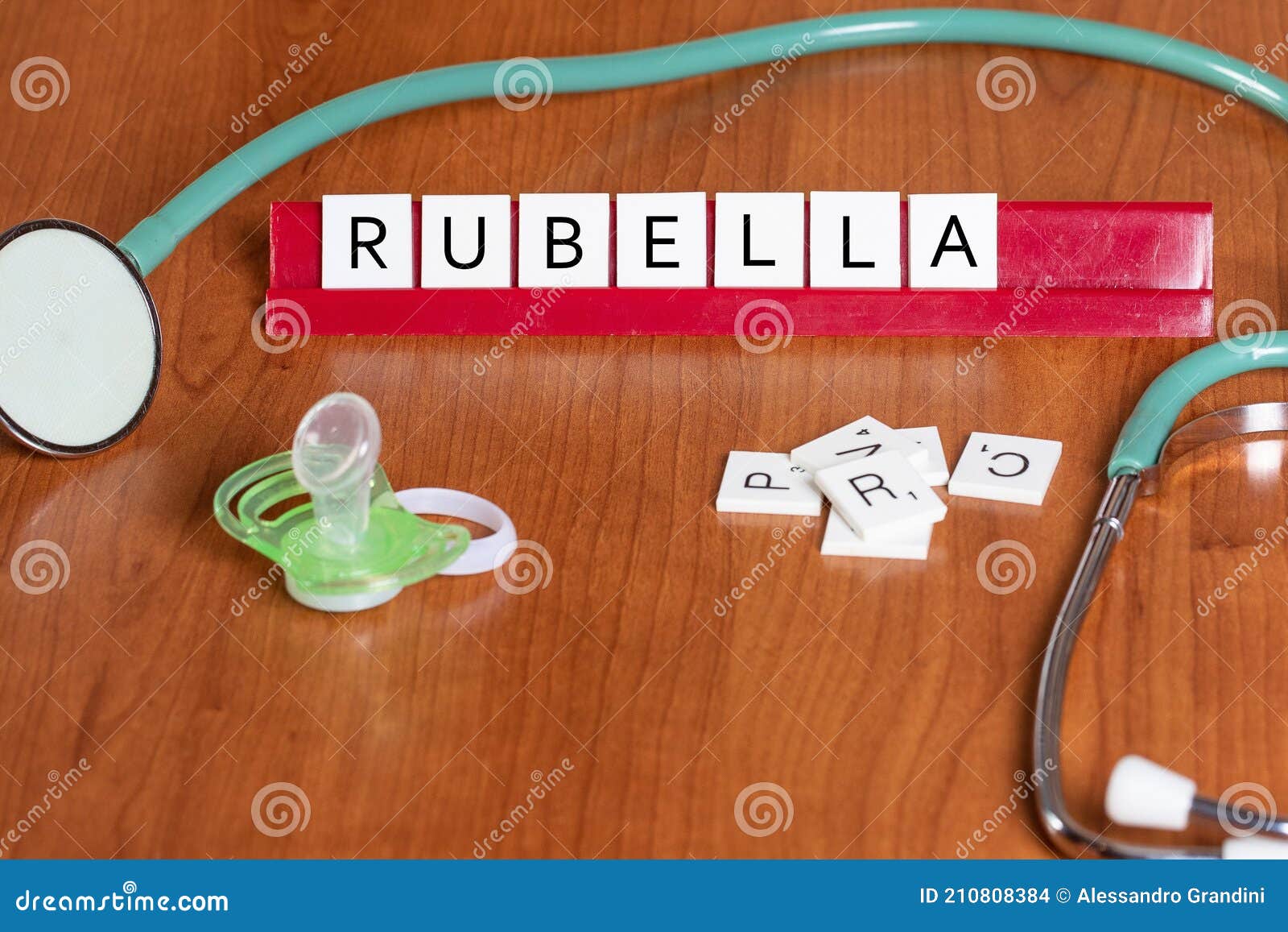detail of stethoscope on table with rubella written reproduced with scrubble letters, pacifier