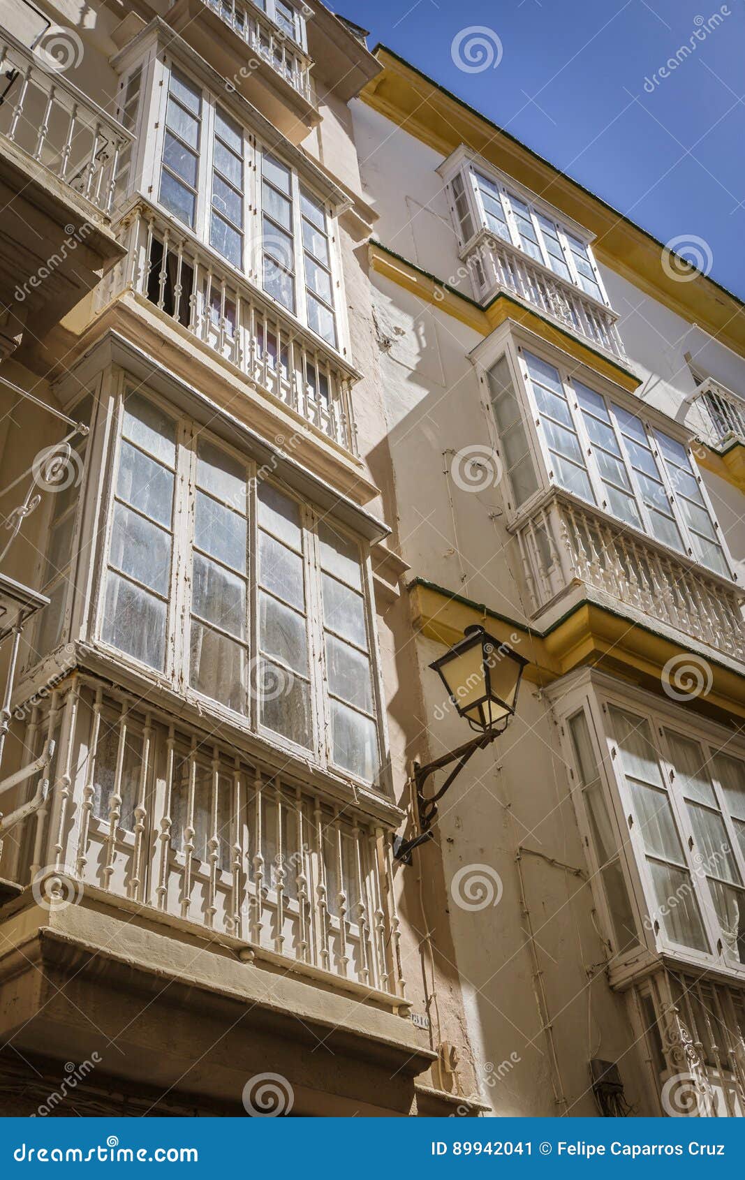 Detalj av balkonger och stora fönster på tiden av nineteen. Detalj av balkonger och stora fönster på tiden av århundradet för th 19, smal gata med traditionell arkitektur i Cadiz, Andalusia, sydliga Spanien