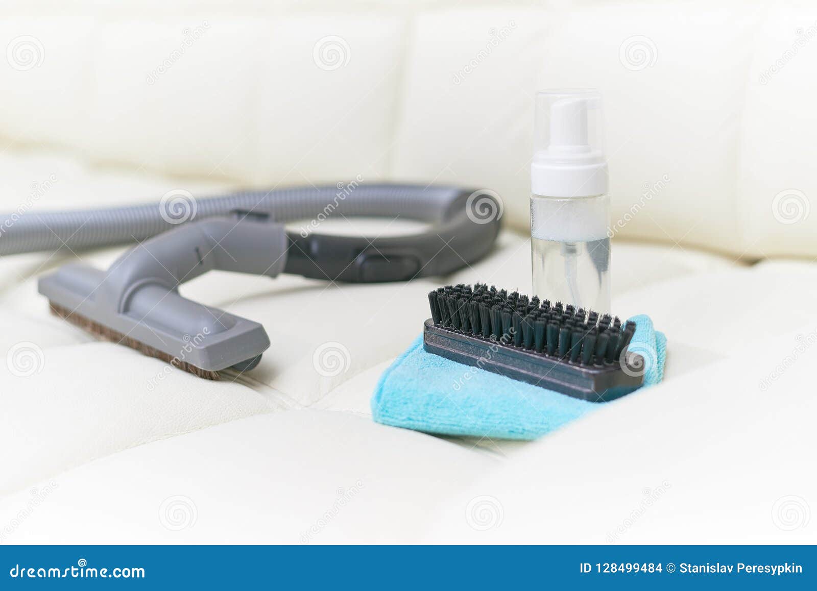 Detergent Brush, Rag and Vacuum Cleaner Lie on the Leather Couch. Stock