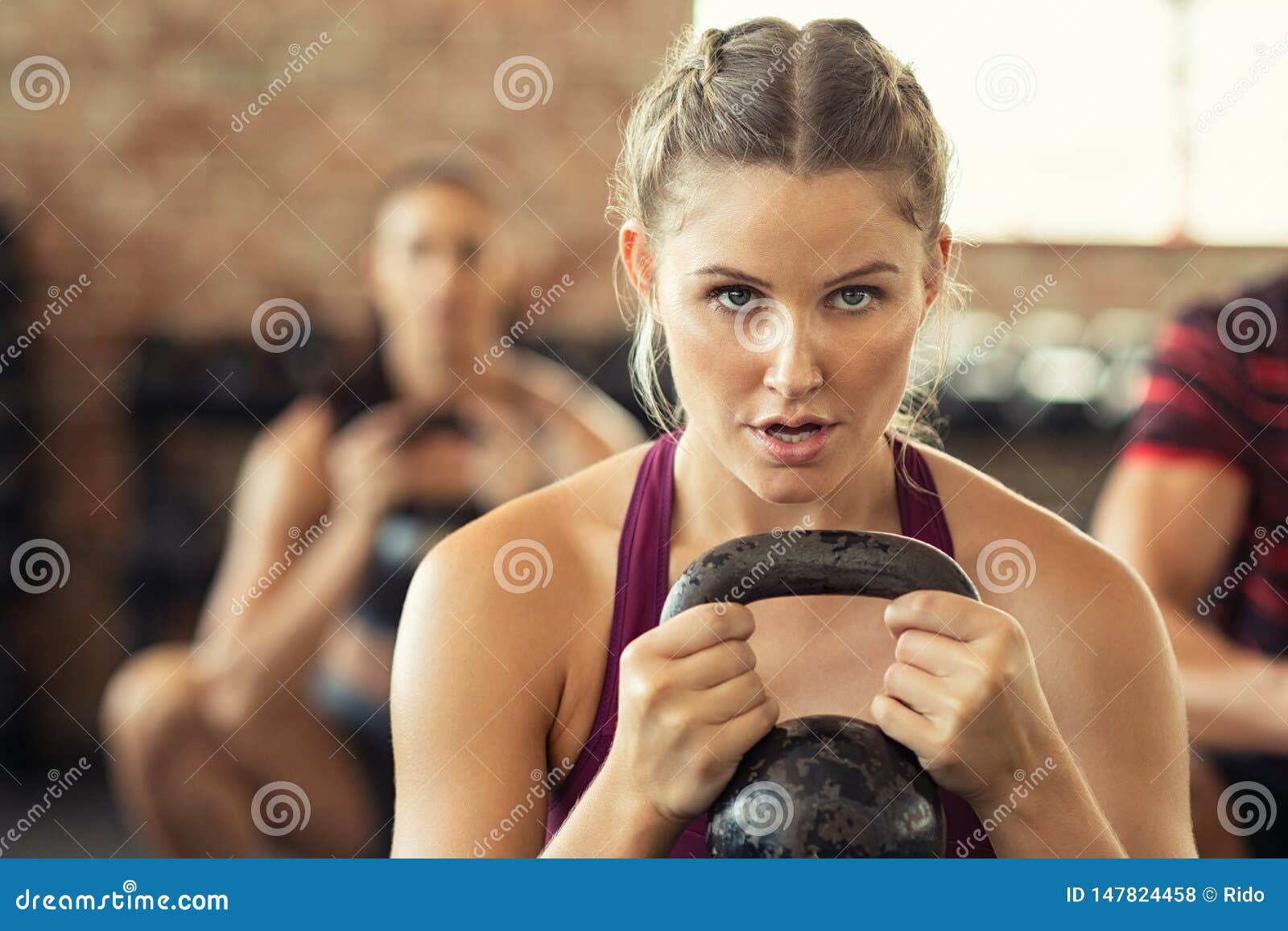 Determined Fitness Woman Doing Squat With Kettle Bell Stock Photo