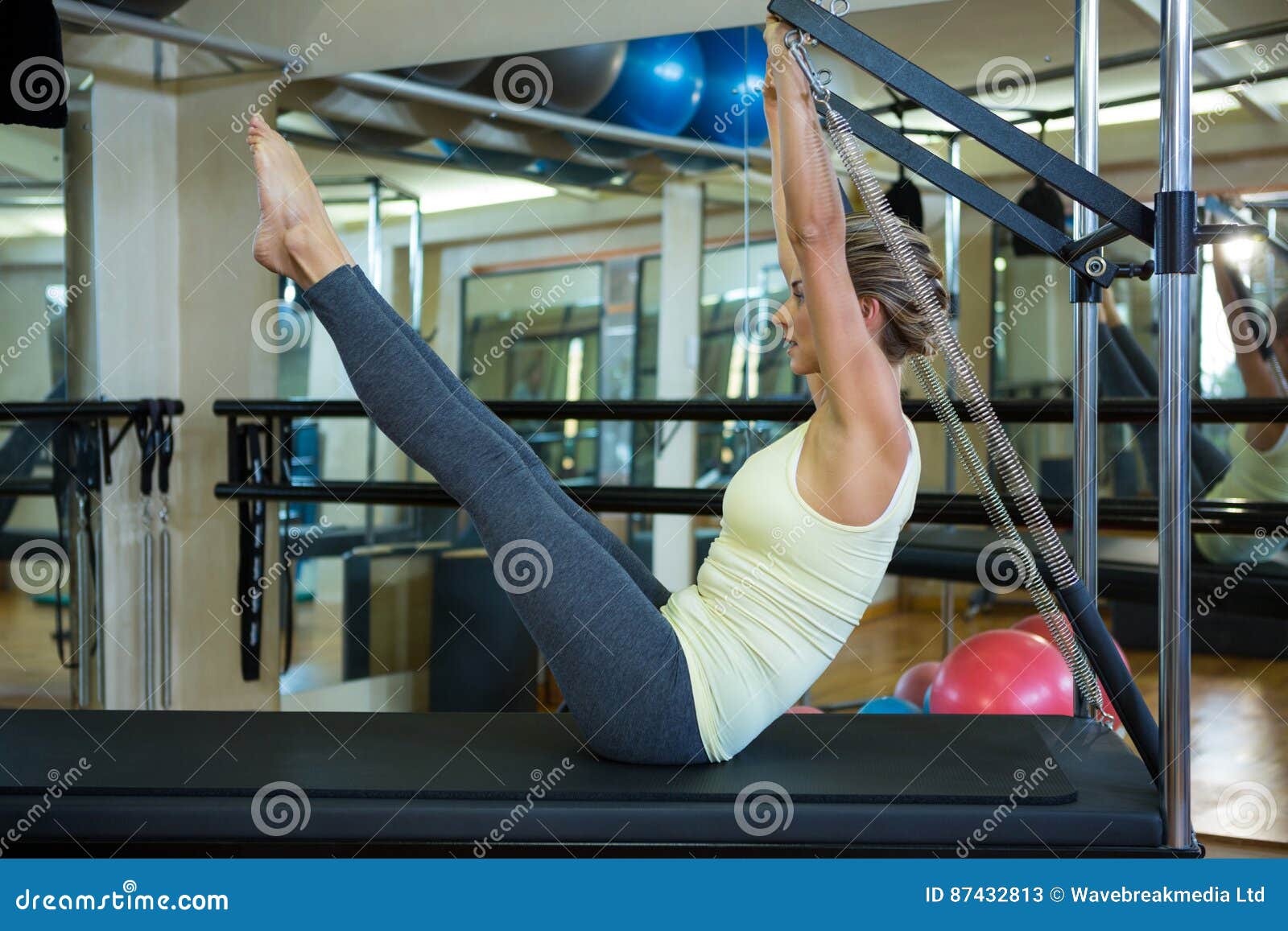 Determined Woman Performing Stretching Exercise on Reformer Stock Image ...