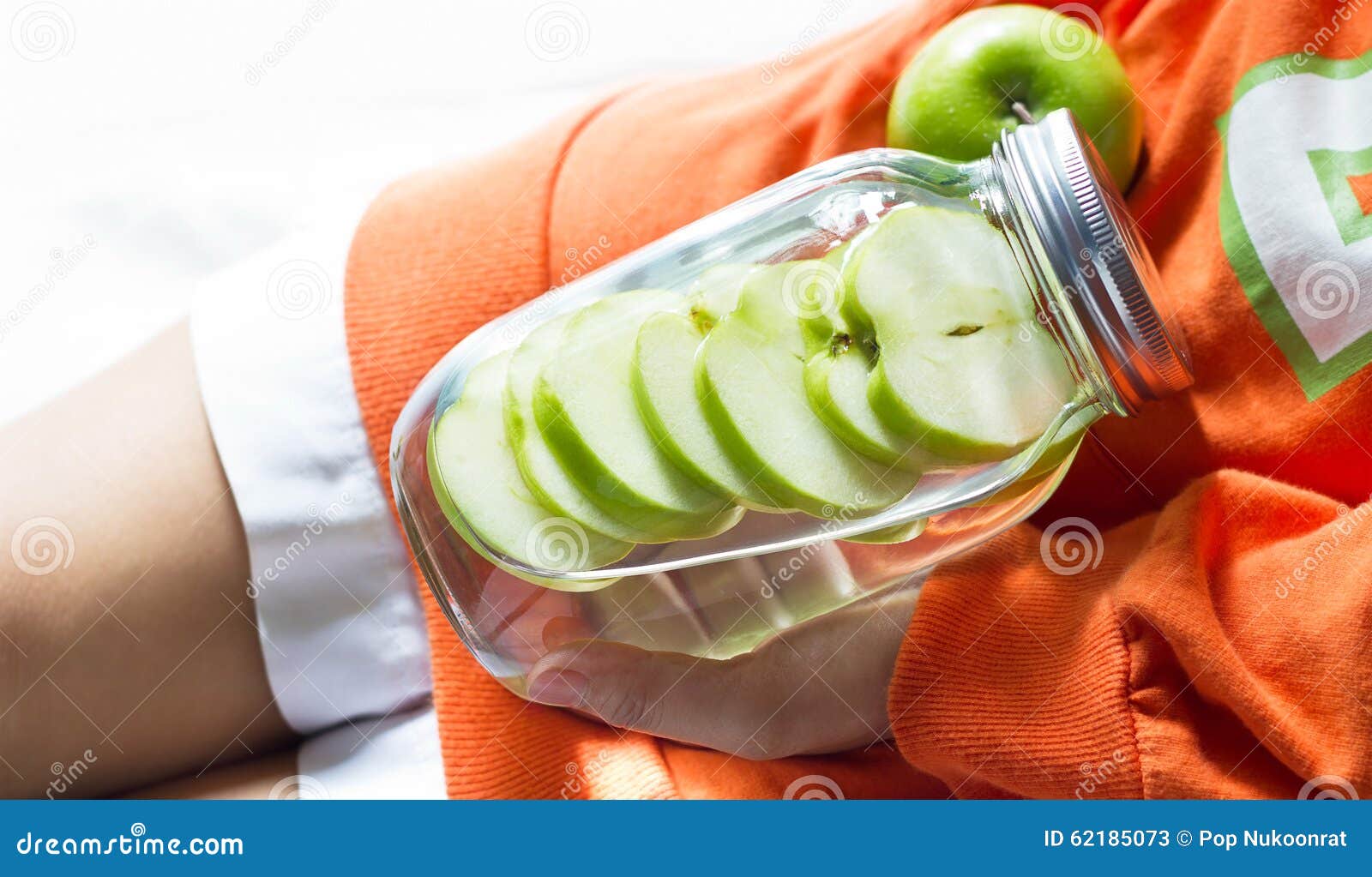detox diet fresh green apples soak in water of the jar in woman hand
