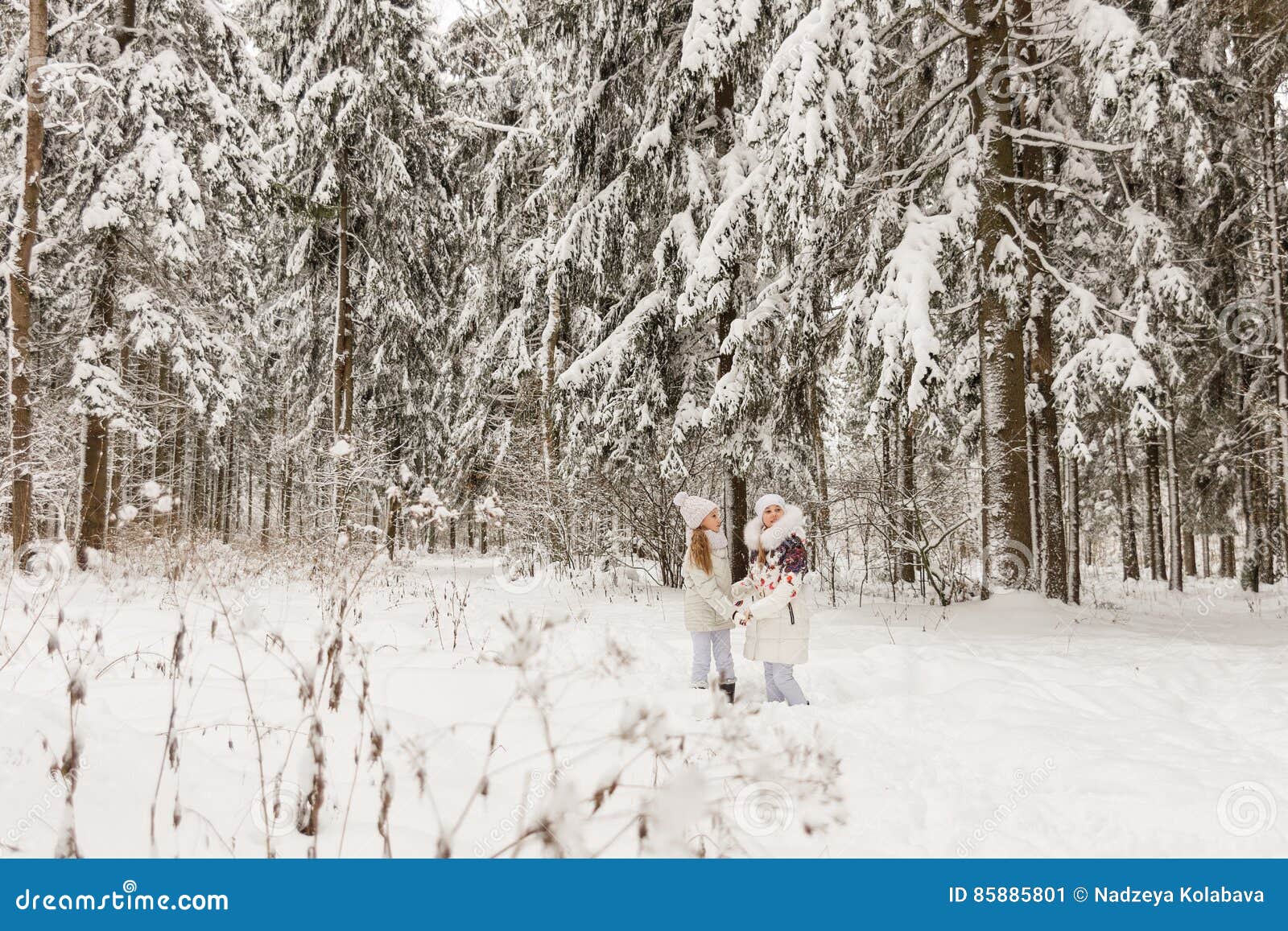 Deux amies jouant dans une forêt d'hiver les soeurs ont un repos en plein air en hiver