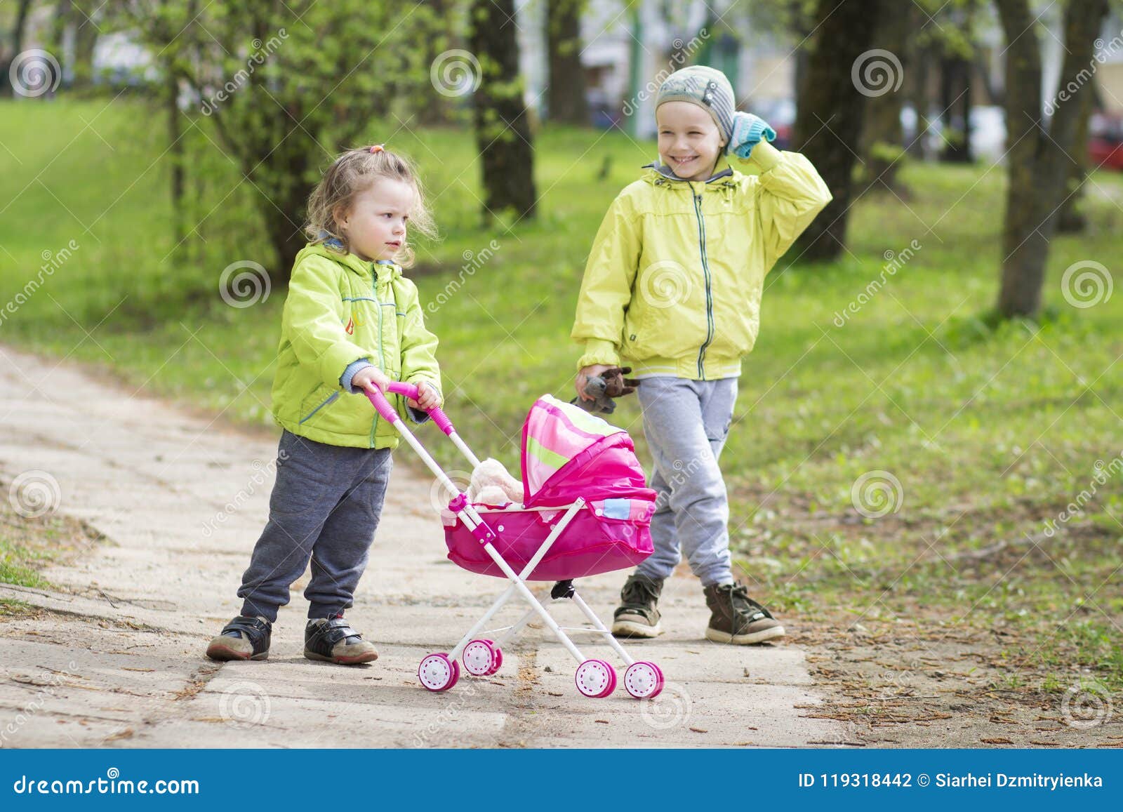 Petite Fille Poussant Une Poussette De Jouet Avec La Poupée Photo stock -  Image du poussette, huche: 57824982