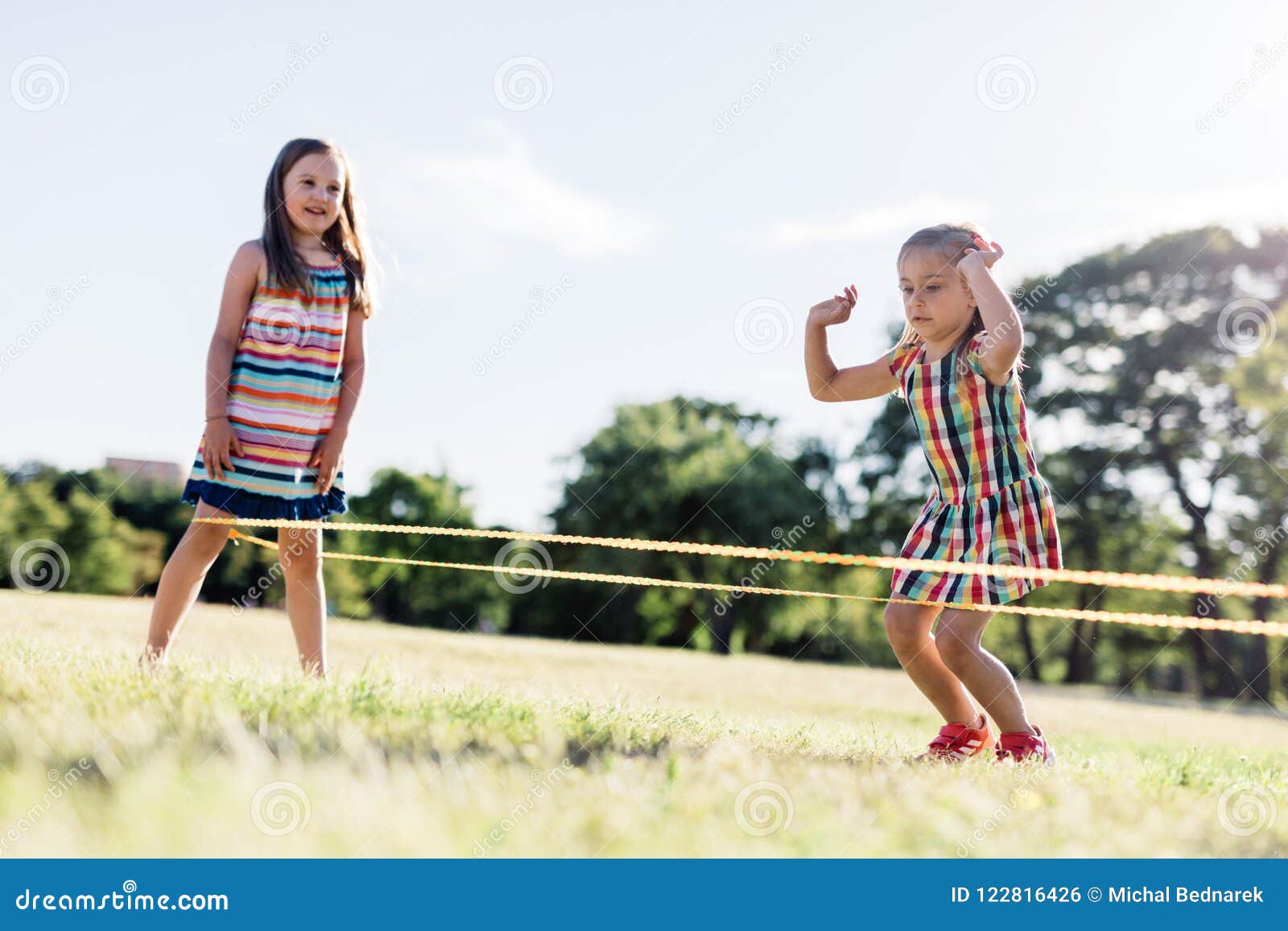 Deux Filles Jouant La Corde à Sauter Chinoise En Parc Photo stock