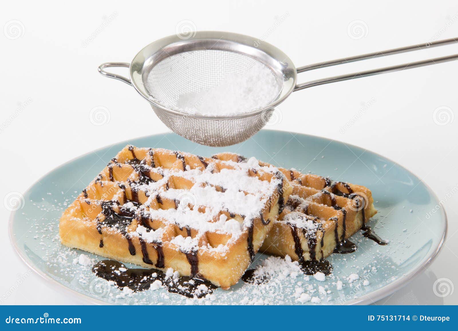 Deux gaufres avec du chocolat et le sucre en poudre d'un plat bleuâtre. Deux gaufres avec du chocolat d'un plat bleuâtre Du sucre en poudre tombe par un tamis