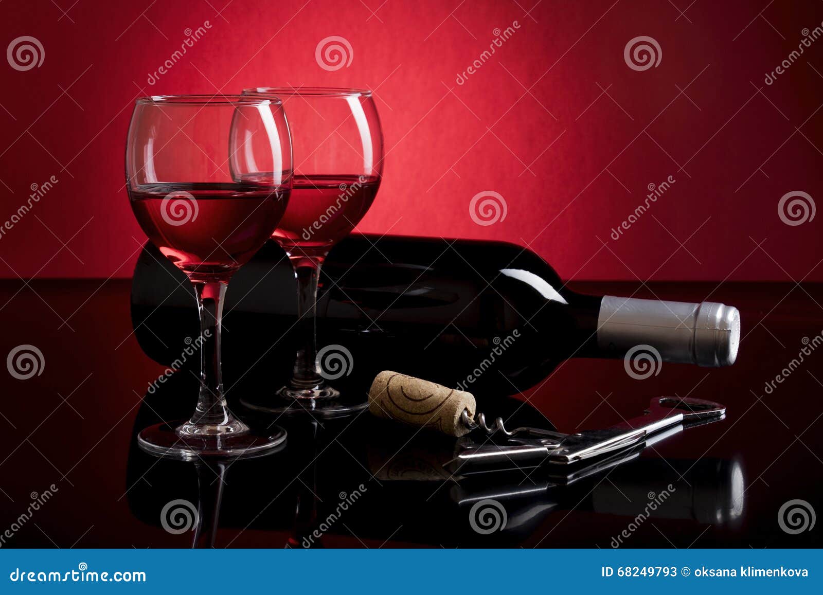 Composition avec deux verres de vin rouge, de bouteille et de crokcrew sur le fond rouge et noir