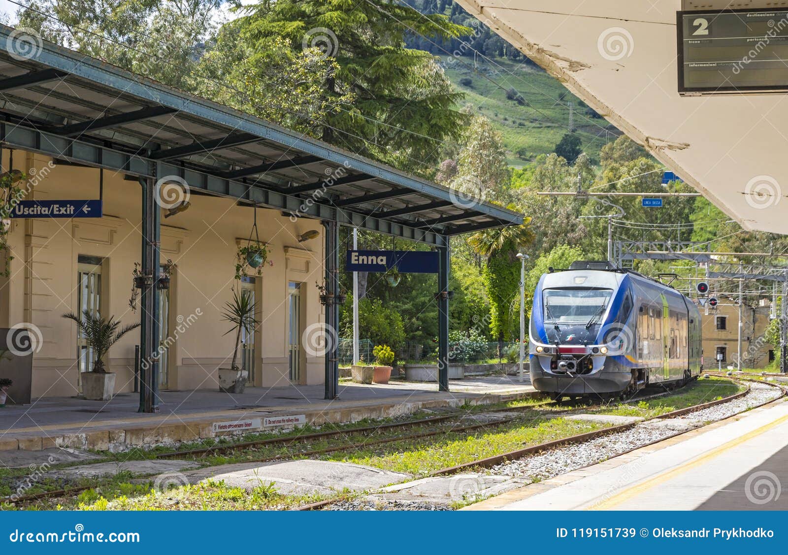 Di Энна Stazione железнодорожного вокзала Энны, Сицилия, Италия. ЭННА, ИТАЛИЯ - 9-ОЕ МАЯ 2018: Поезд приезжает к di Энне Stazione железнодорожного вокзала Энны, малому железнодорожному вокзалу расположенному в 5km отсутствующее хорошо под городком Энны старым, Сицилией, Италией