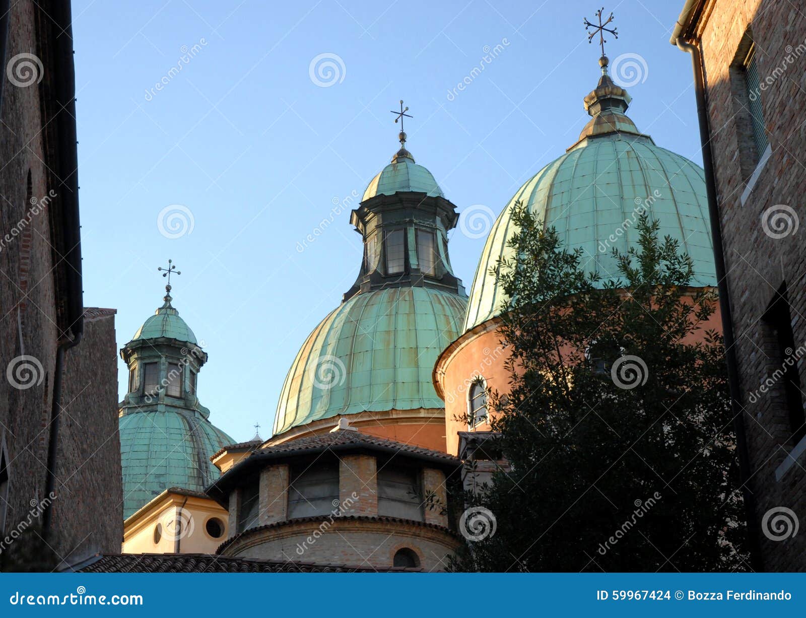 Die drei Hauben der Kathedrale in Treviso im Venetien (Italien). Foto gemacht mit den Hauben der Kathedrale in Treviso im Venetien (Italien) Im Bild geschildert durch eine kleine Gasse, die südlich der Kirche gelegen ist, sehen Sie, gestaltet durch Wände von zwei Häusern und durch den blauen Himmel, die drei ausgerichteten Hauben Das zweite, anders als das erste besitzen eine breite Lampe