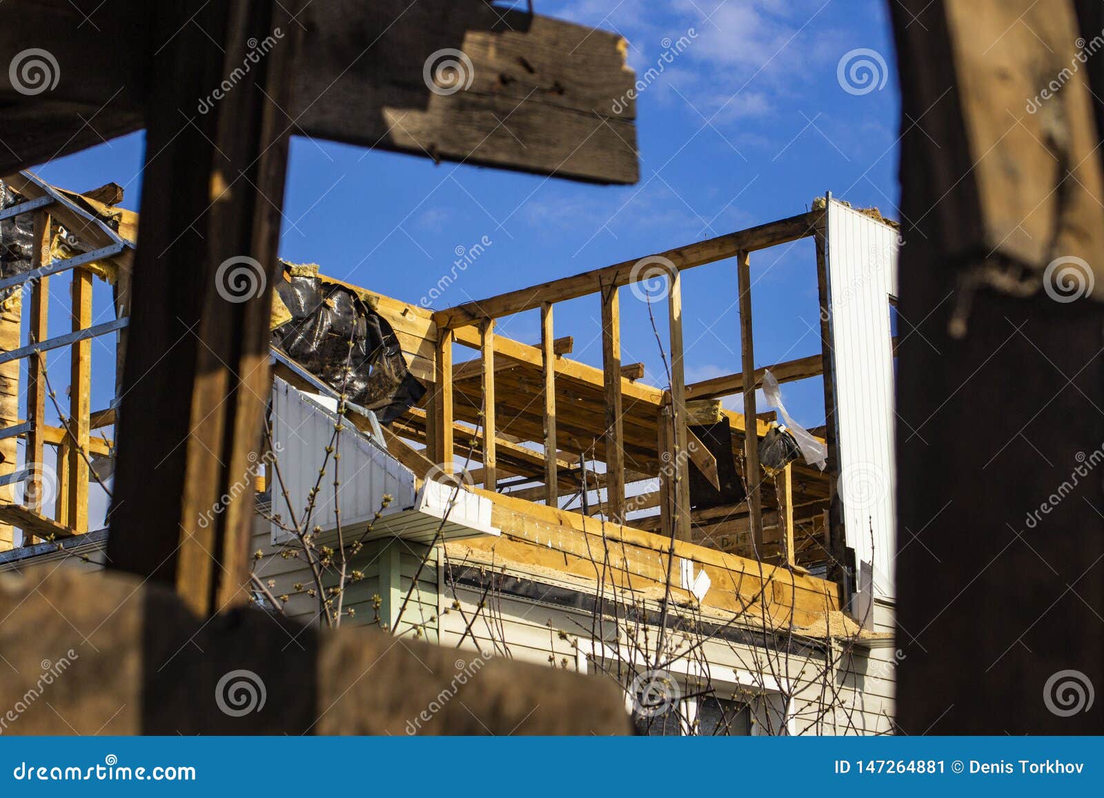 The destruction of the walls of the old building and the cleaning of construction debris with a bucket of an excavator. Die Zerstörung der Wände des Altbaus und der Reinigung des Baurückstands mit einem Eimer eines excavat