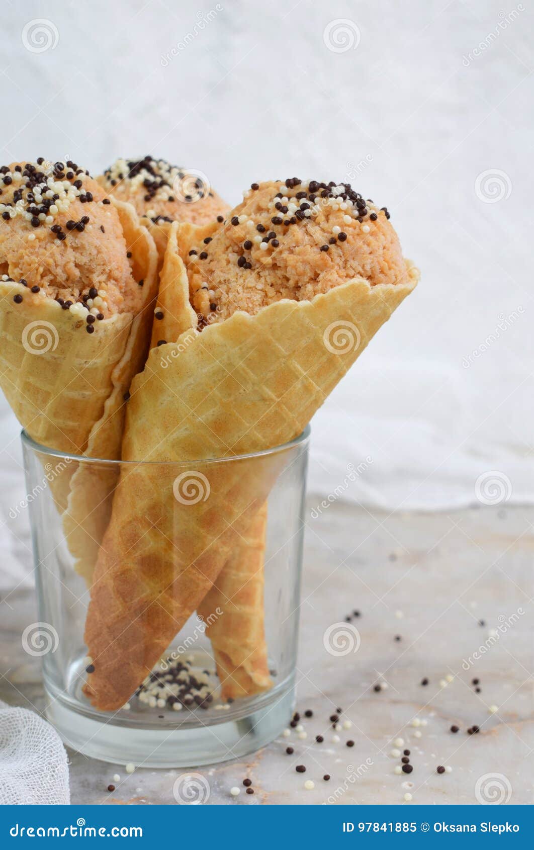dietary caramel colored apple ice cream in waffle cone on a light background. copy space