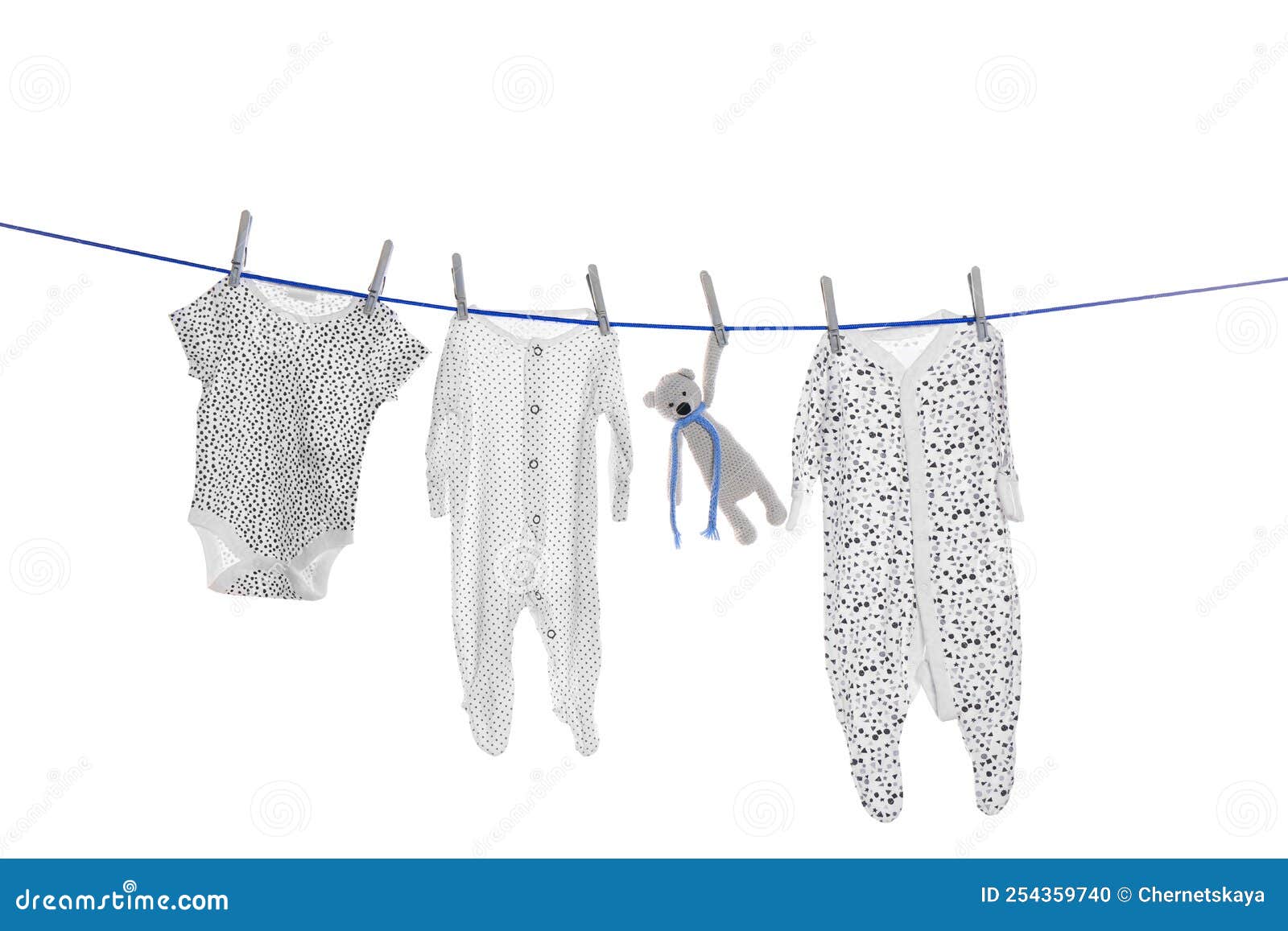 Different Baby Clothes and Toy Drying on Laundry Line Against