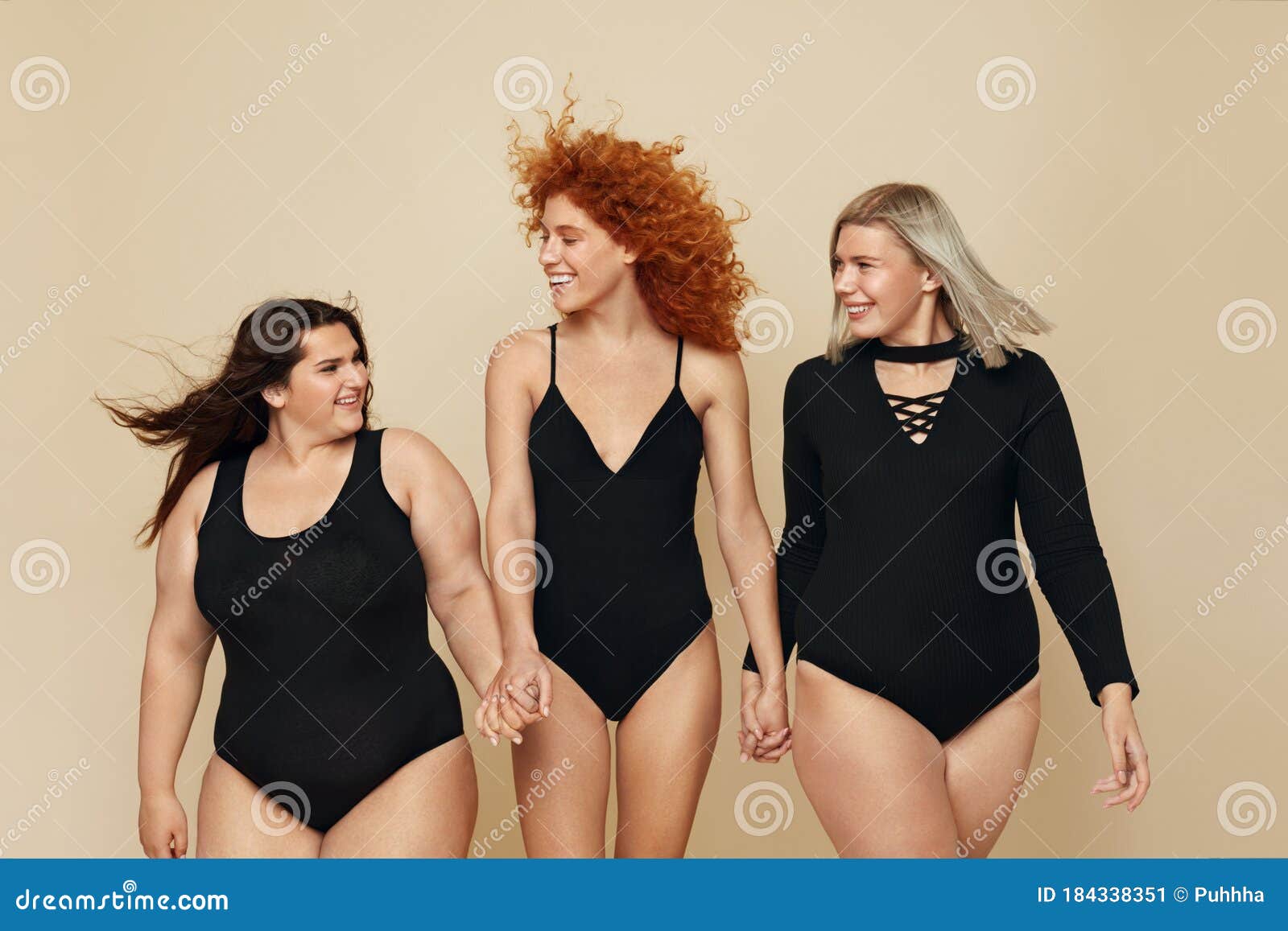 different body types. group of diversity models portrait. cheerful blonde, brunette and redhead in black bodysuits holding hands.