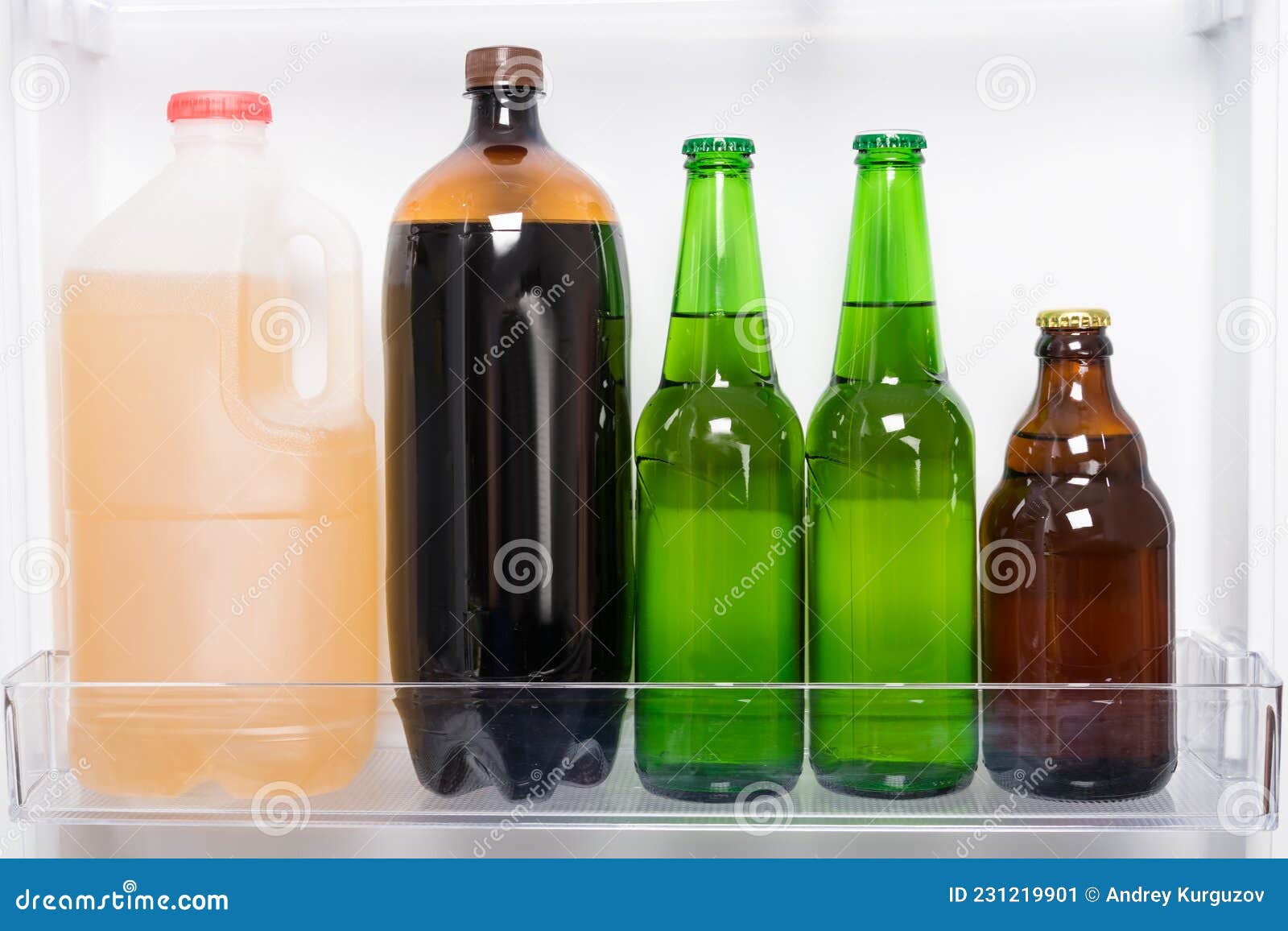 Different Bottles of Beer are on the Shelf in the Refrigerator Door
