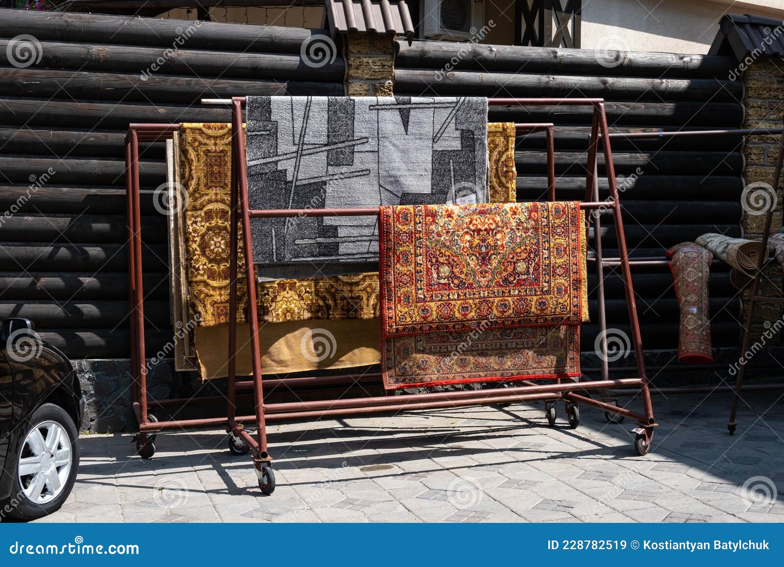 Different Carpets Hanging on Rack Outdoors. Professional Carpet Cleaning and Drying Stock Image