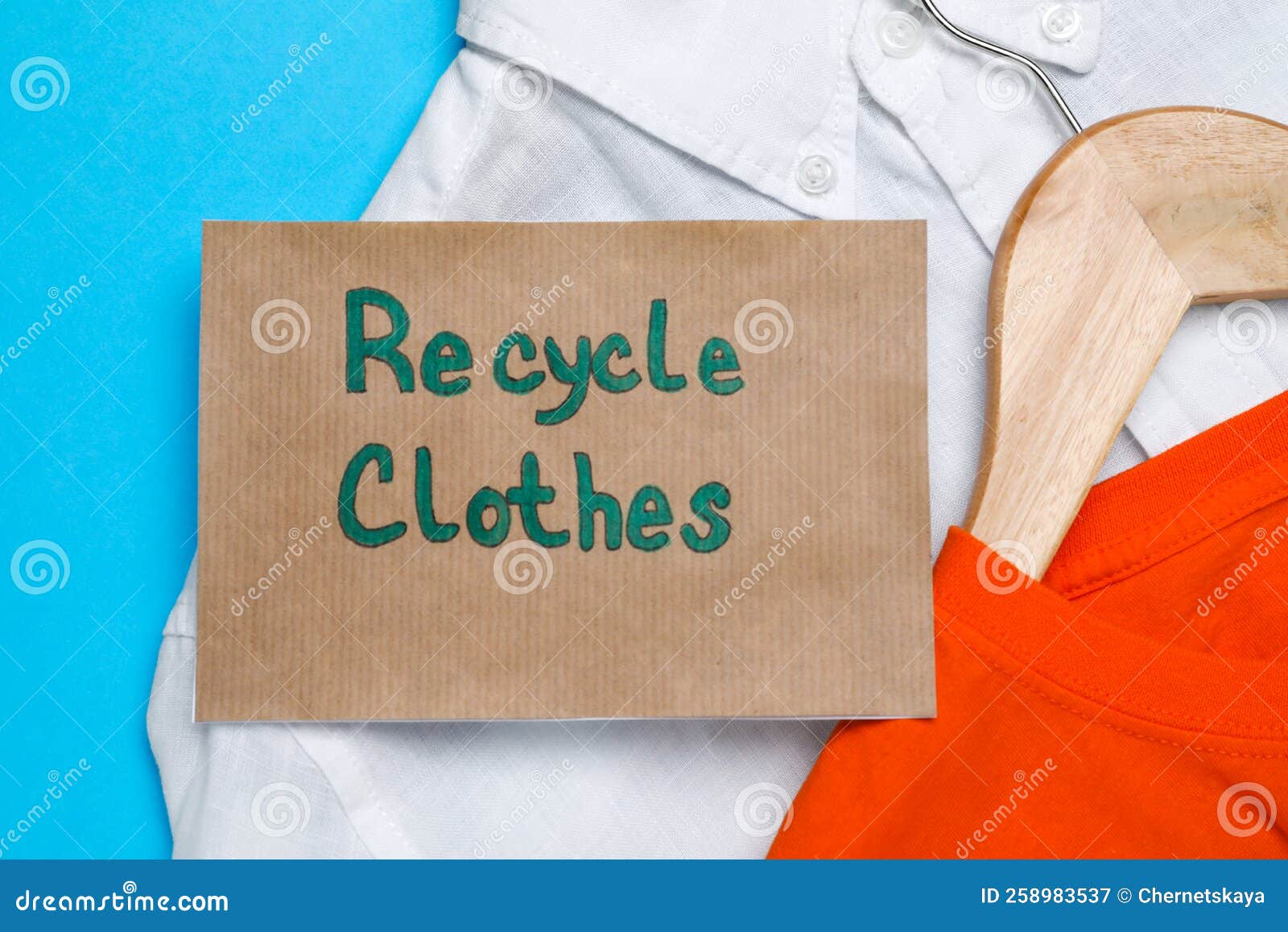 Different Clothes with Recycling Label on Light Blue Background, Flat