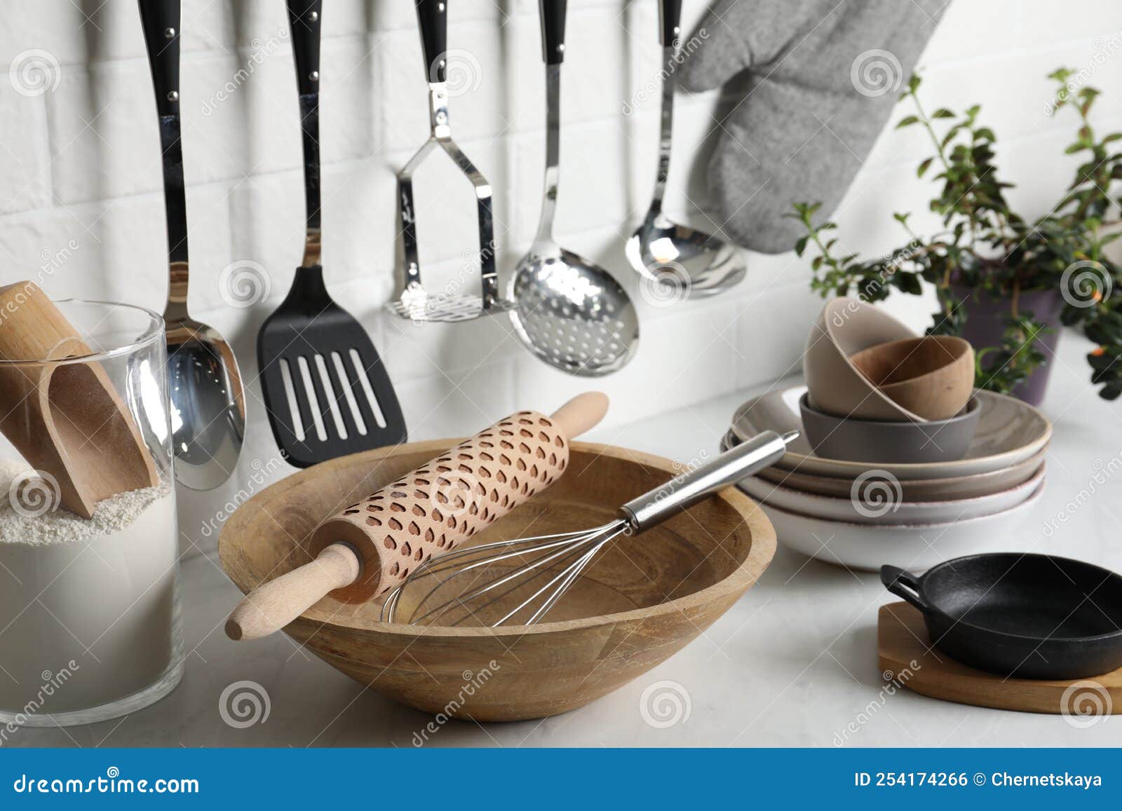 Different Cooking Utensils and Plant on Countertop in Kitchen Stock