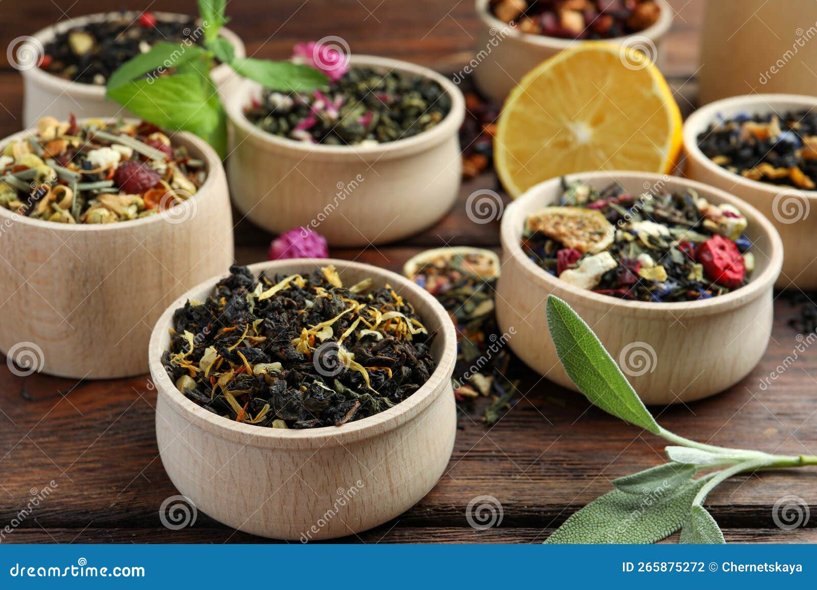 Different Kinds of Dry Herbal Tea in Bowls on Wooden Table Stock Photo