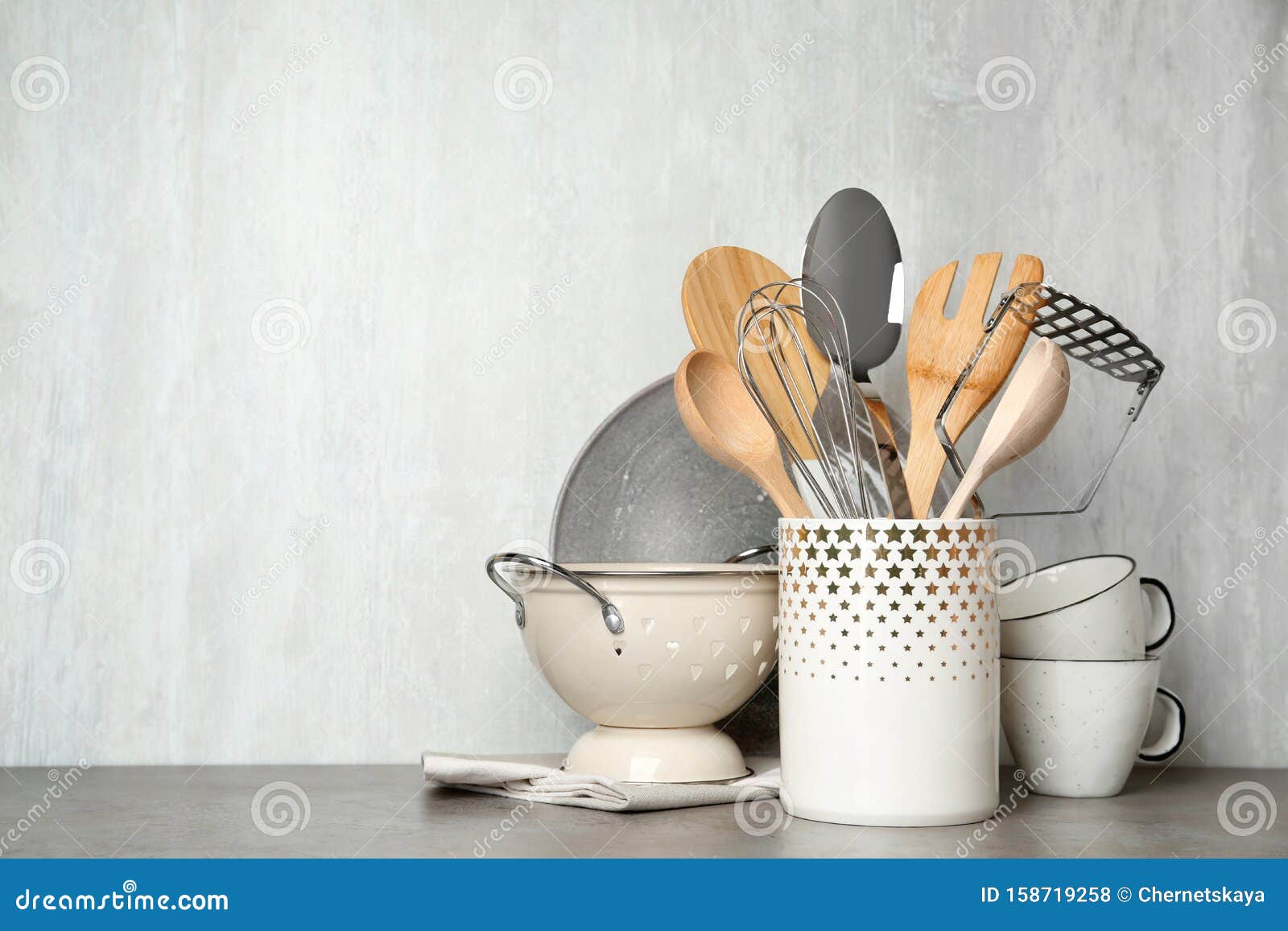 Different Kitchen Utensils on Grey Table Against Light Background Stock