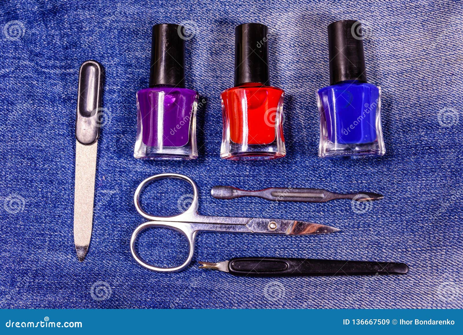 Different Manicure Tools and Nail Polishes on the Blue Jeans. Top View