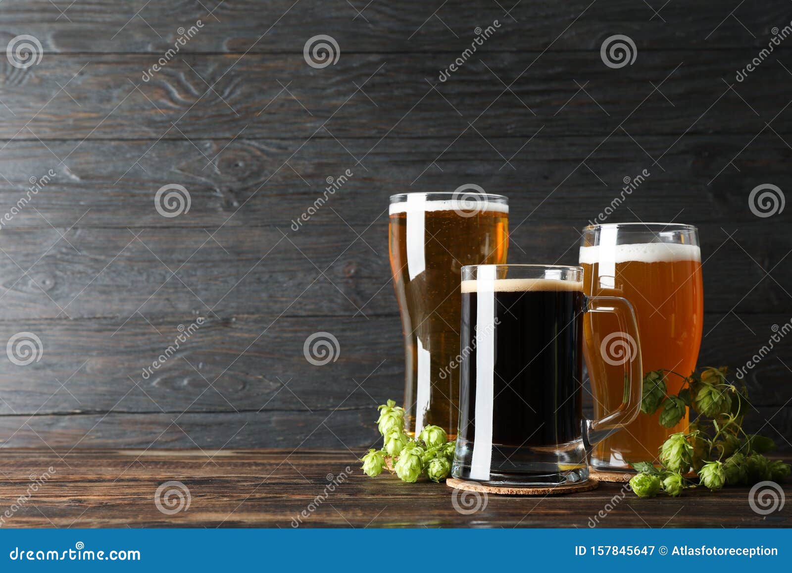 Different Mugs with Beer and Hop Cones on Wooden Table Stock Image Image of beverage, bubble