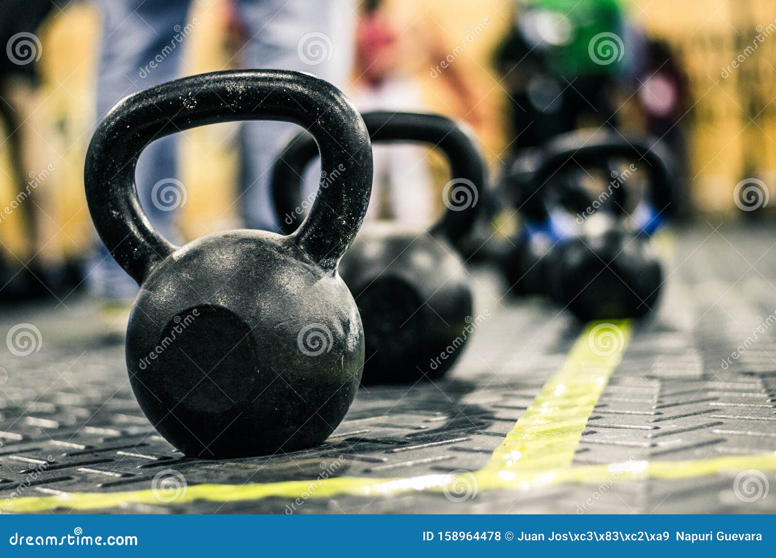 different sizes of kettlebells weights lying on gym floor.