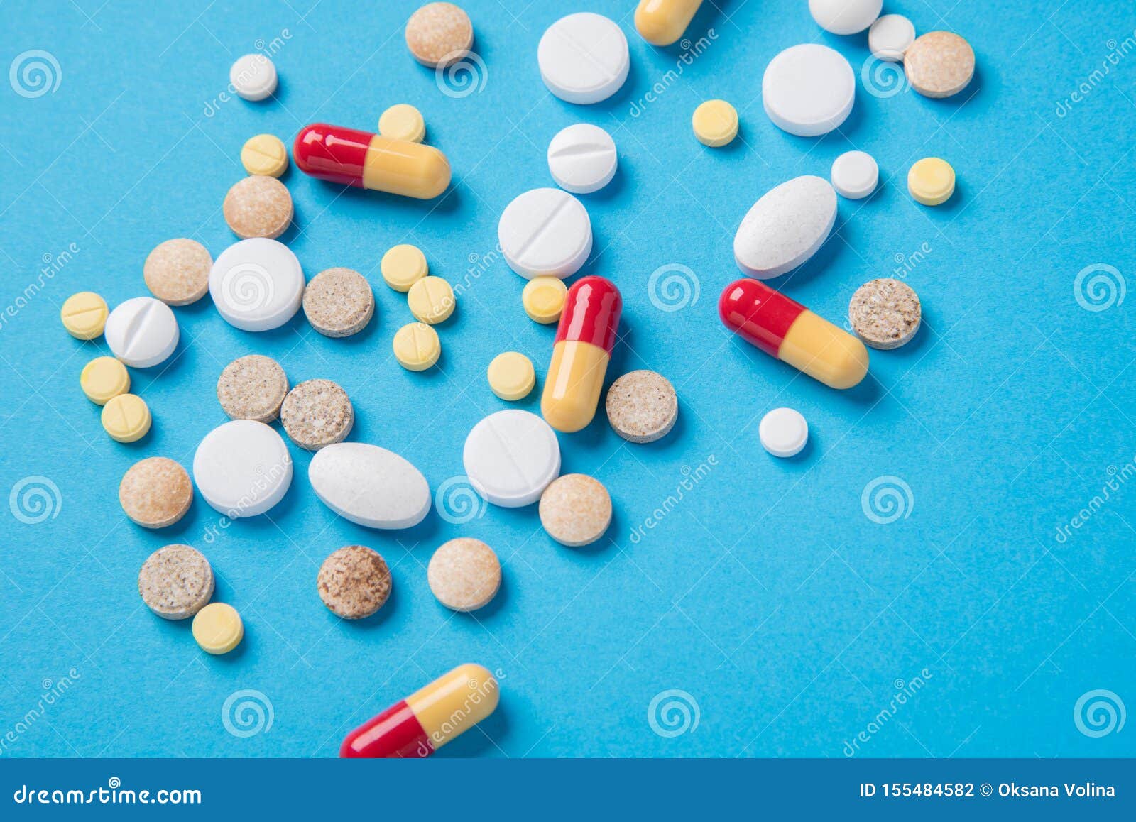 Different Tablets and Pills in the Package and without it on a Blue