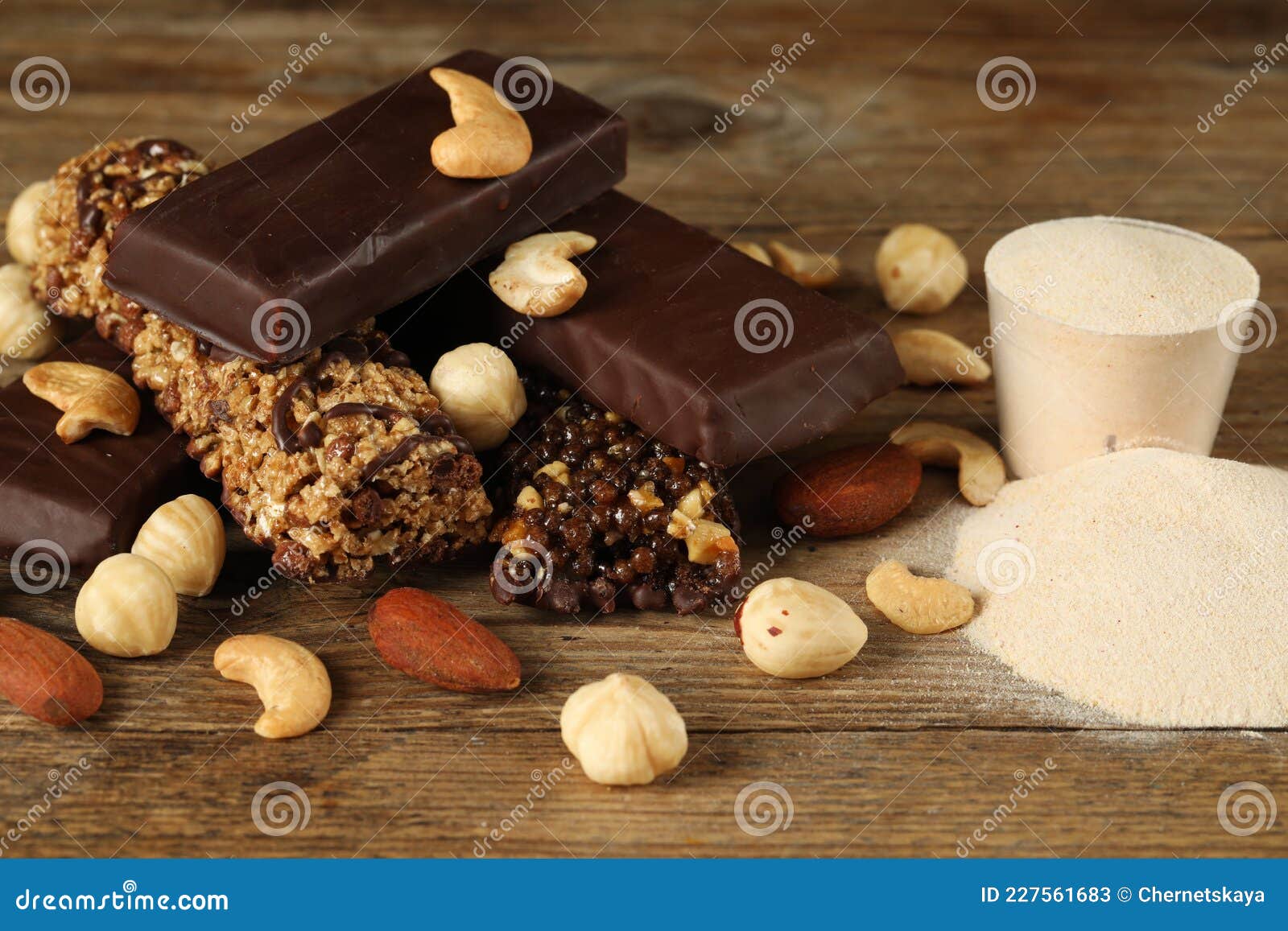 Different Tasty Bars, Nuts and Protein Powder on Wooden Table Stock