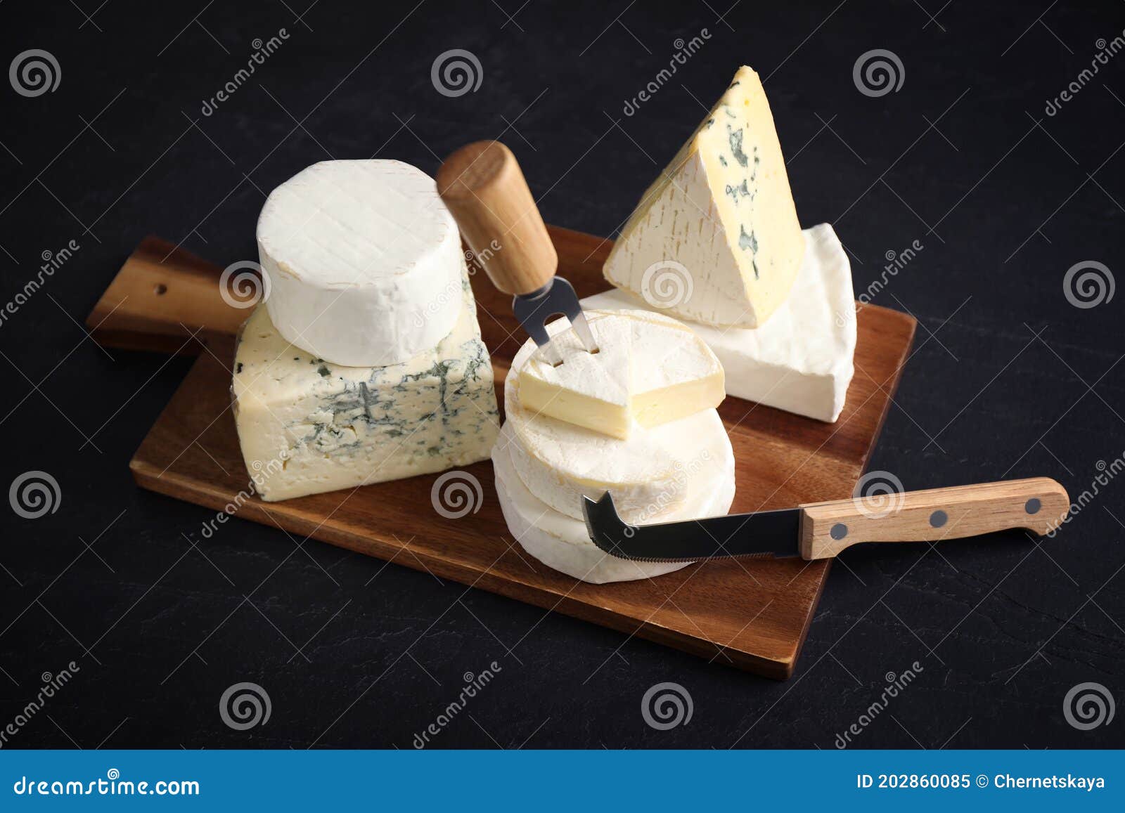 Different Types of Cheese, Knife and Fork on Black Table Stock Image