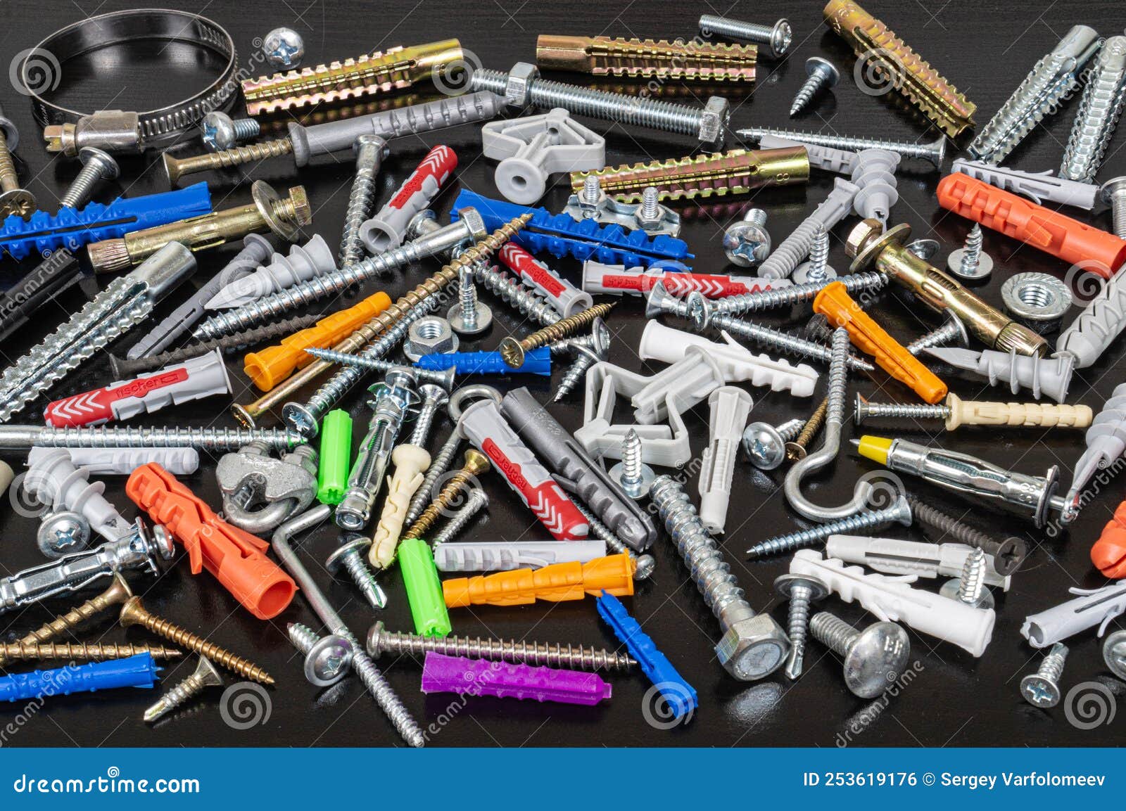 Different Types of Fasteners on a Dark Wood Background. Stock Photo