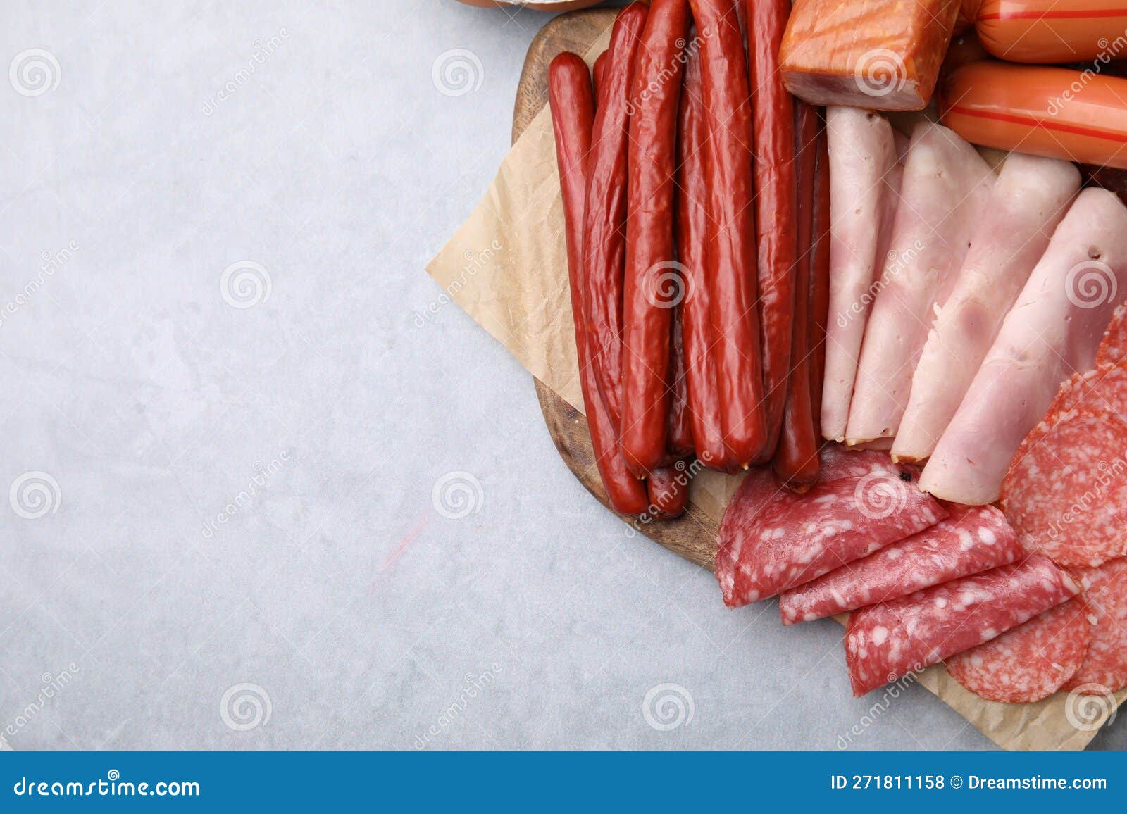 Different Types of Sausages on Light Grey Table, Flat Lay. Space for