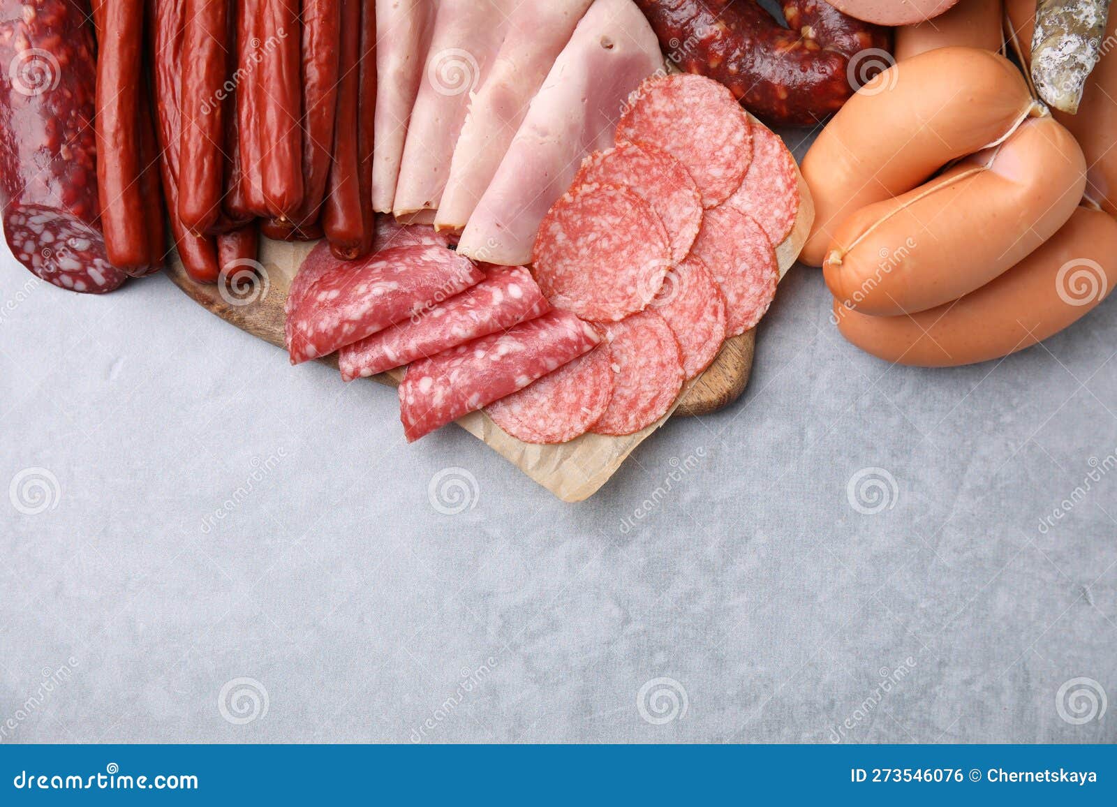 Different Types of Sausages on Light Grey Table, Flat Lay. Space for