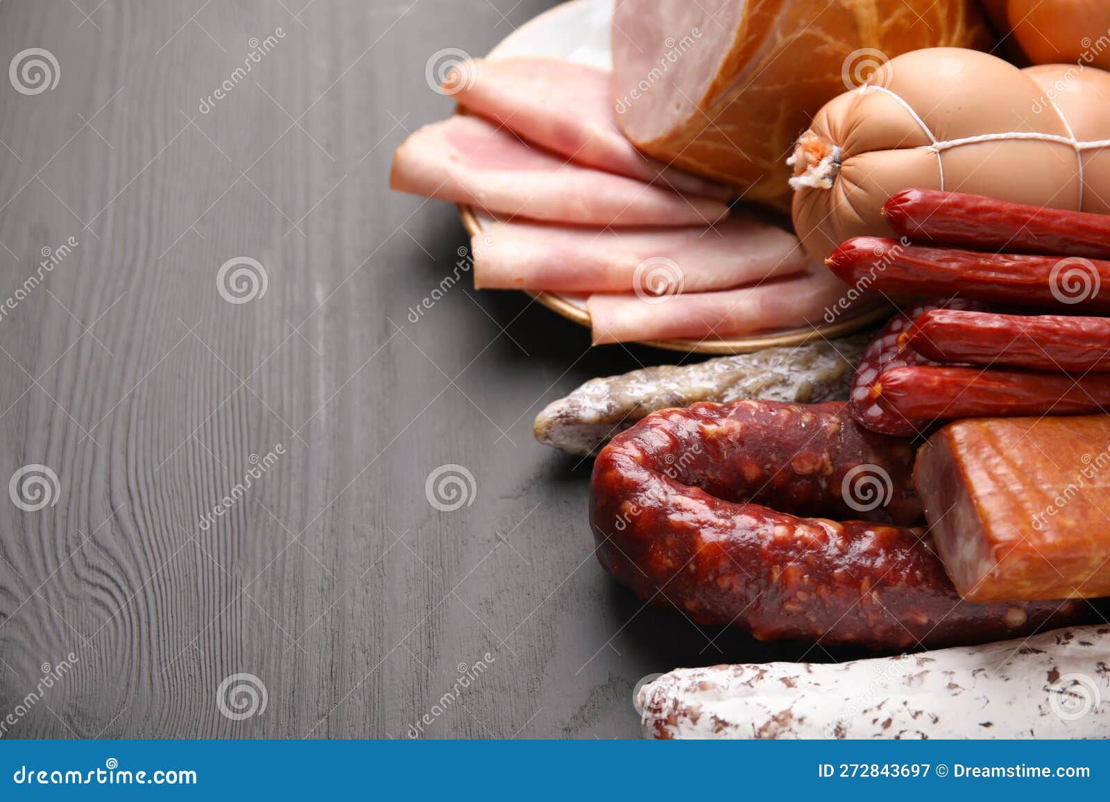 Different Types of Sausages on Light Grey Wooden Table, Closeup. Space