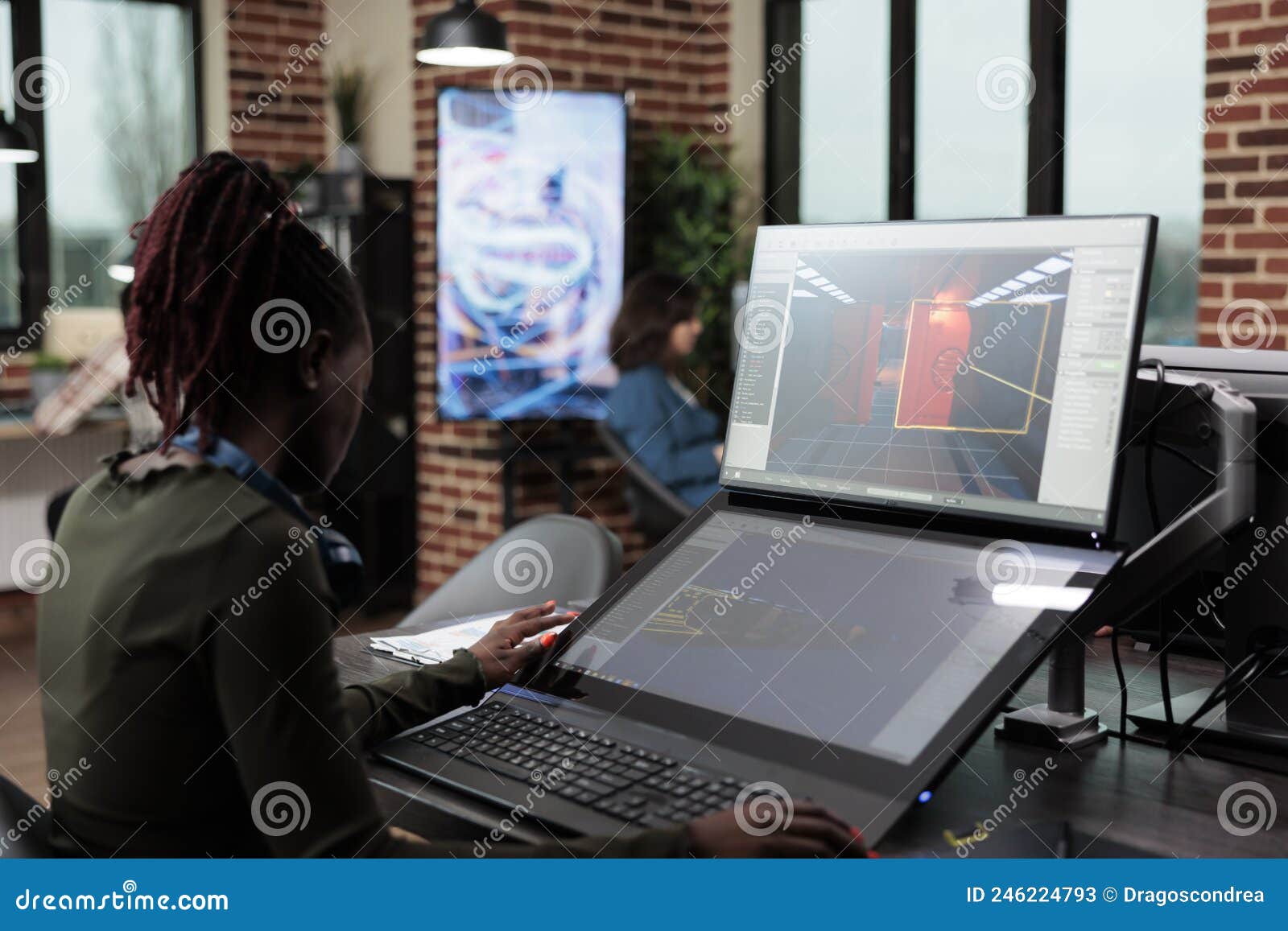 digital artist sitting at desk, using pc to  game environment and levels.