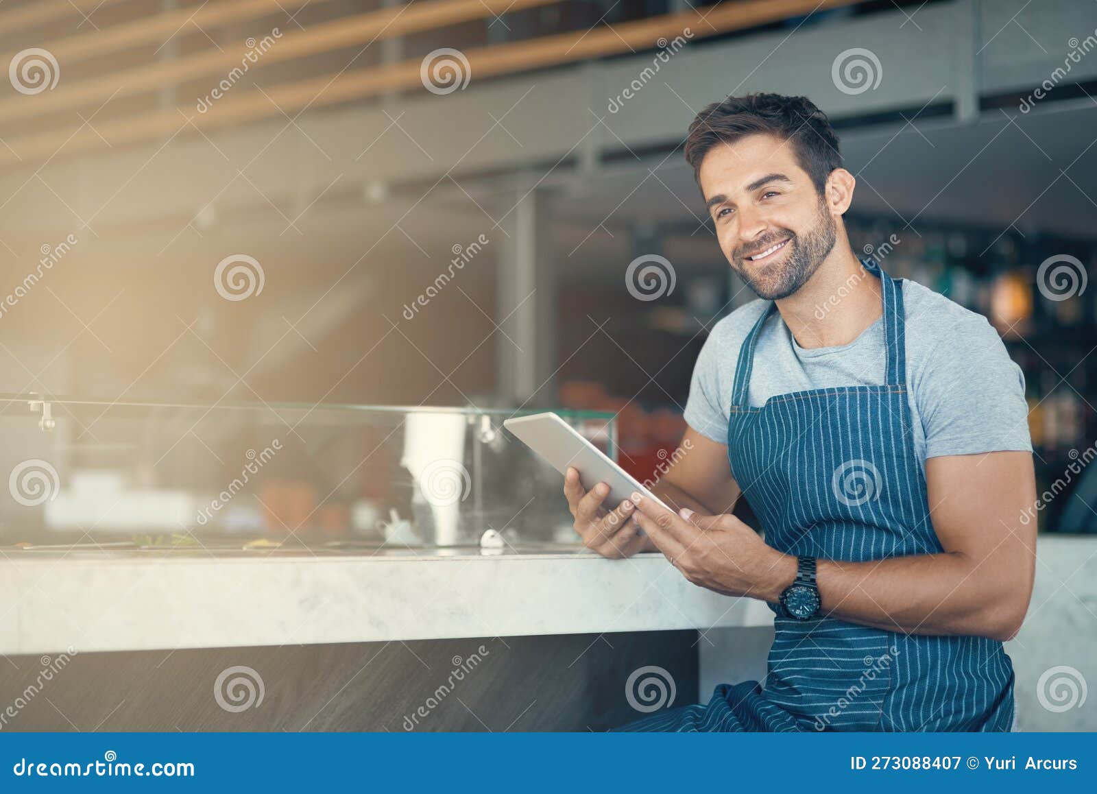 Digitizing My Coffee Shop Managerial Duties. a Young Man Using a Digital Tablet while Working at