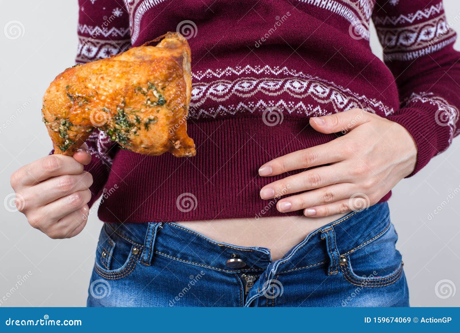 Dikke levensmiddelen eten teveel aan begrip Foto van een meisje dat handpalmen vasthoudt op grote volle buik en na brandend maagz. Dikke levensmiddelen eten teveel aan begrip Foto van een meisje dat handpalm vasthoudt op grote volle onderbuik en zich brandend voelt na vettige vettige, vettige, vettige voedingsbodem geïsoleerde grijze achtergrond