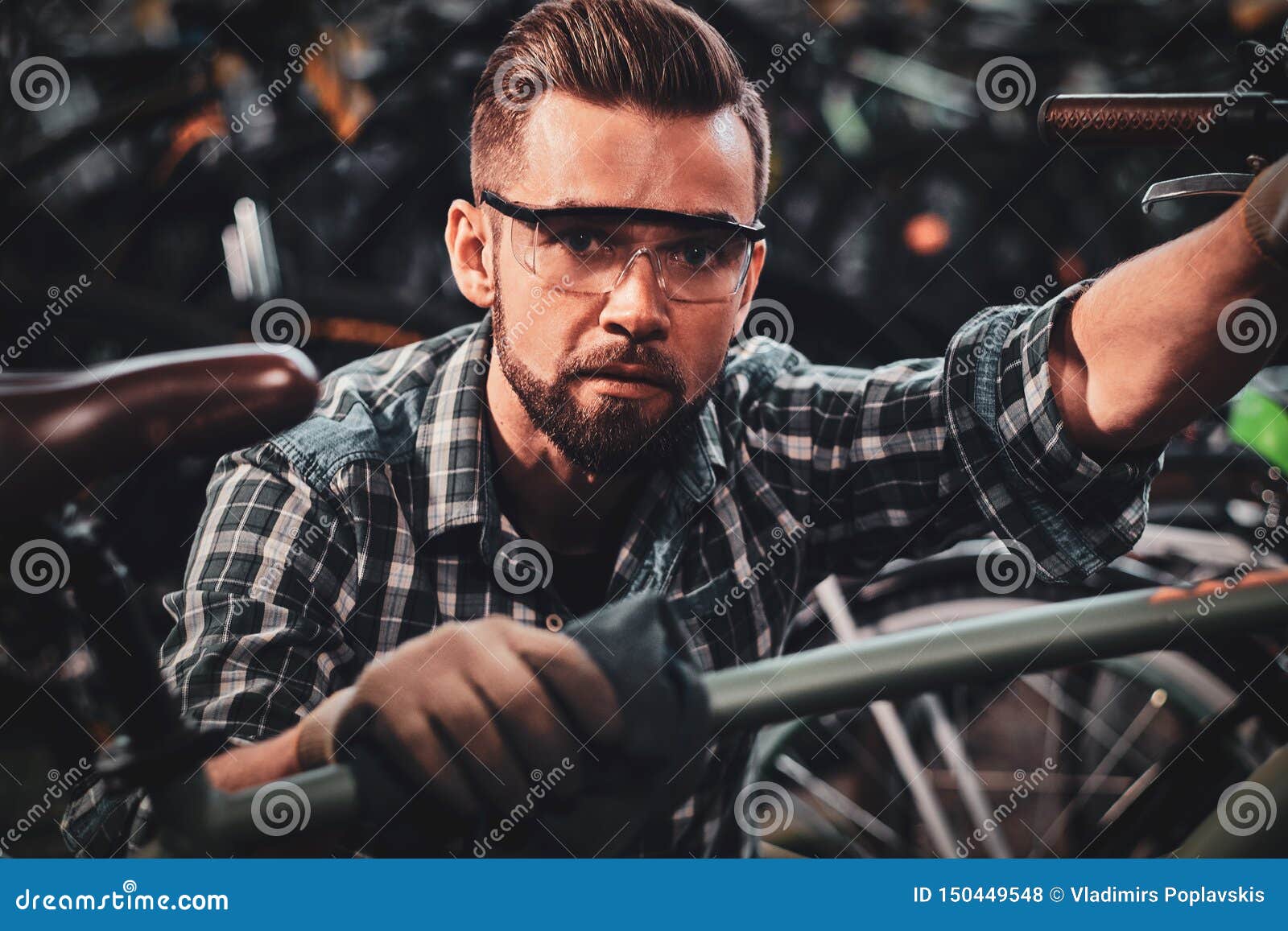 Nice Hardworking Man is Working with Bicycles at Warehouse. Stock Photo