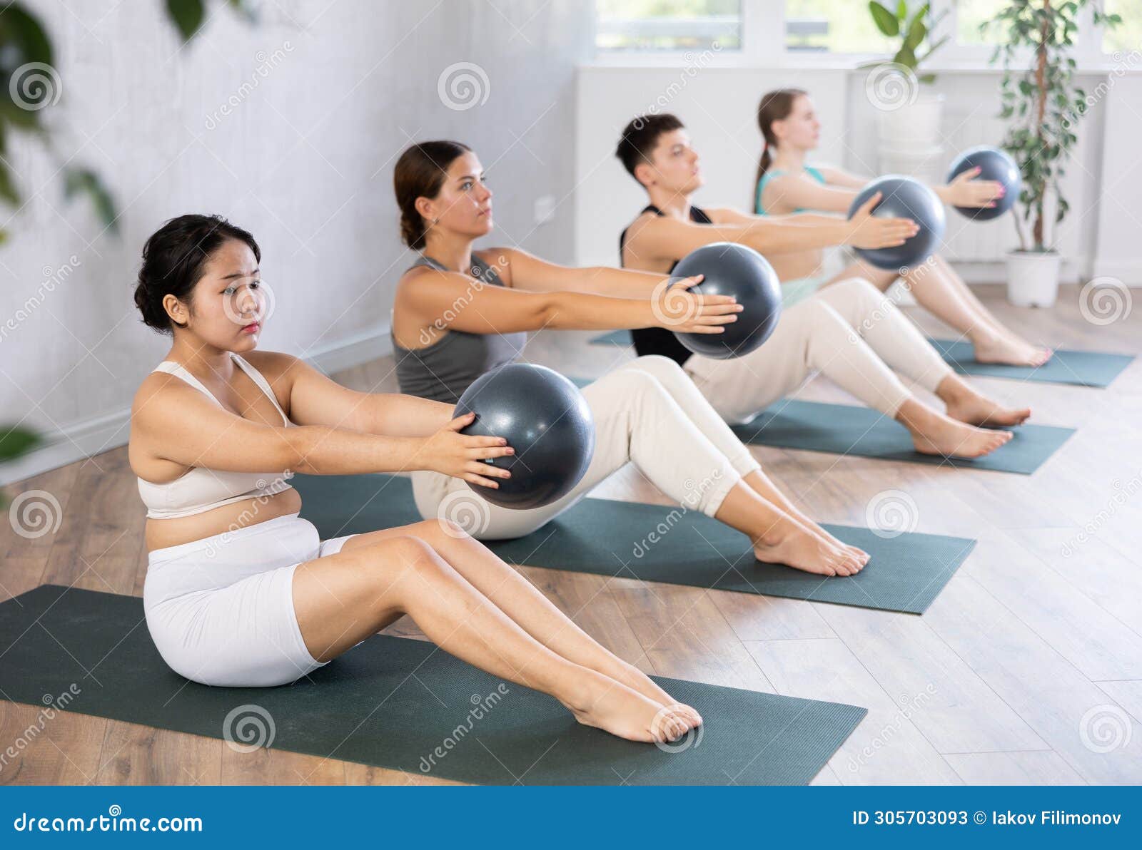 Young Woman Practicing Pilates Pose Holding Softball in Hands in Training  Area Stock Image - Image of active, fullbodied: 305703093