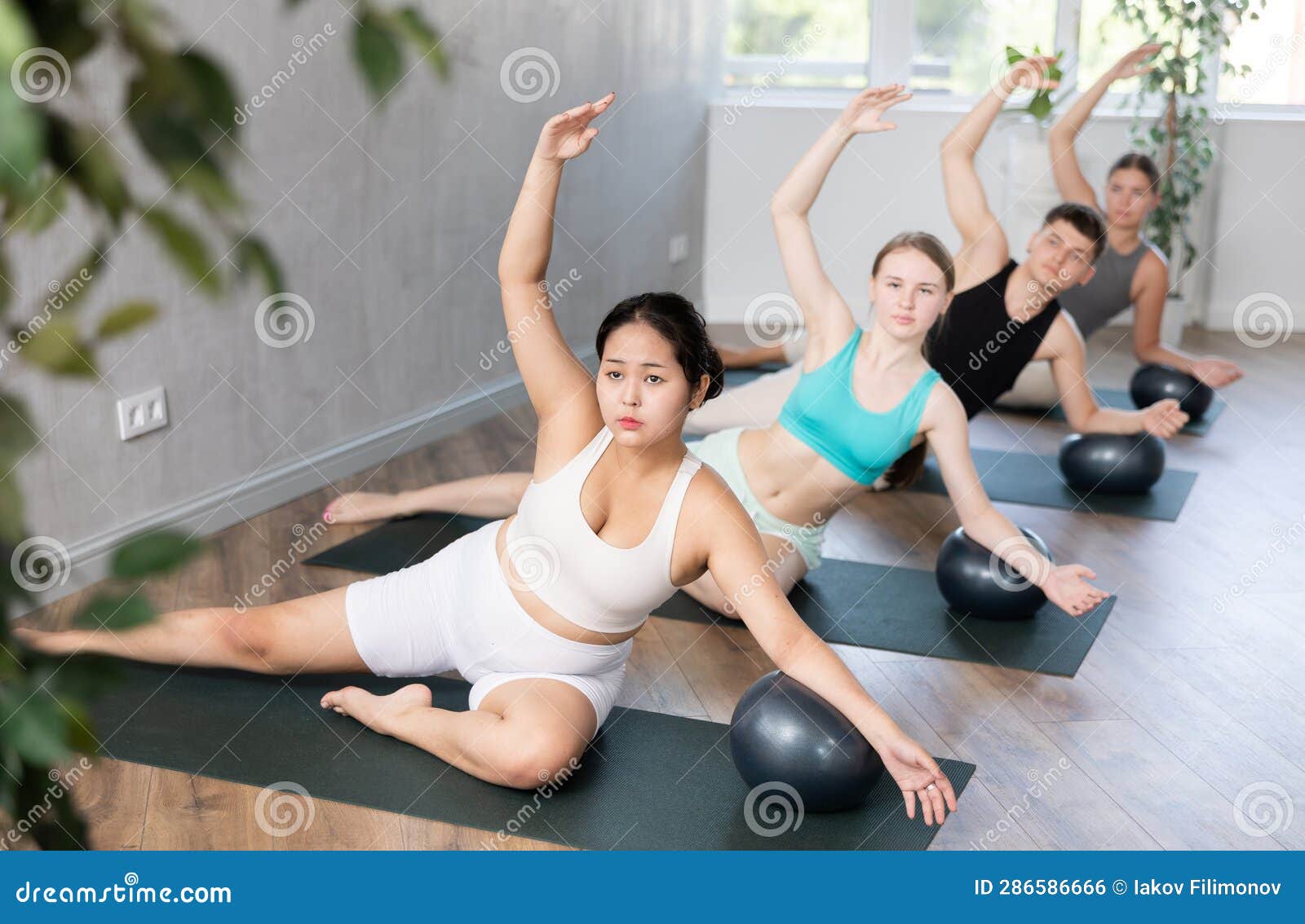 Young Woman Practicing Pilates Pose with Softball Under Arm in Training  Area Stock Photo - Image of healthy, floor: 286586666